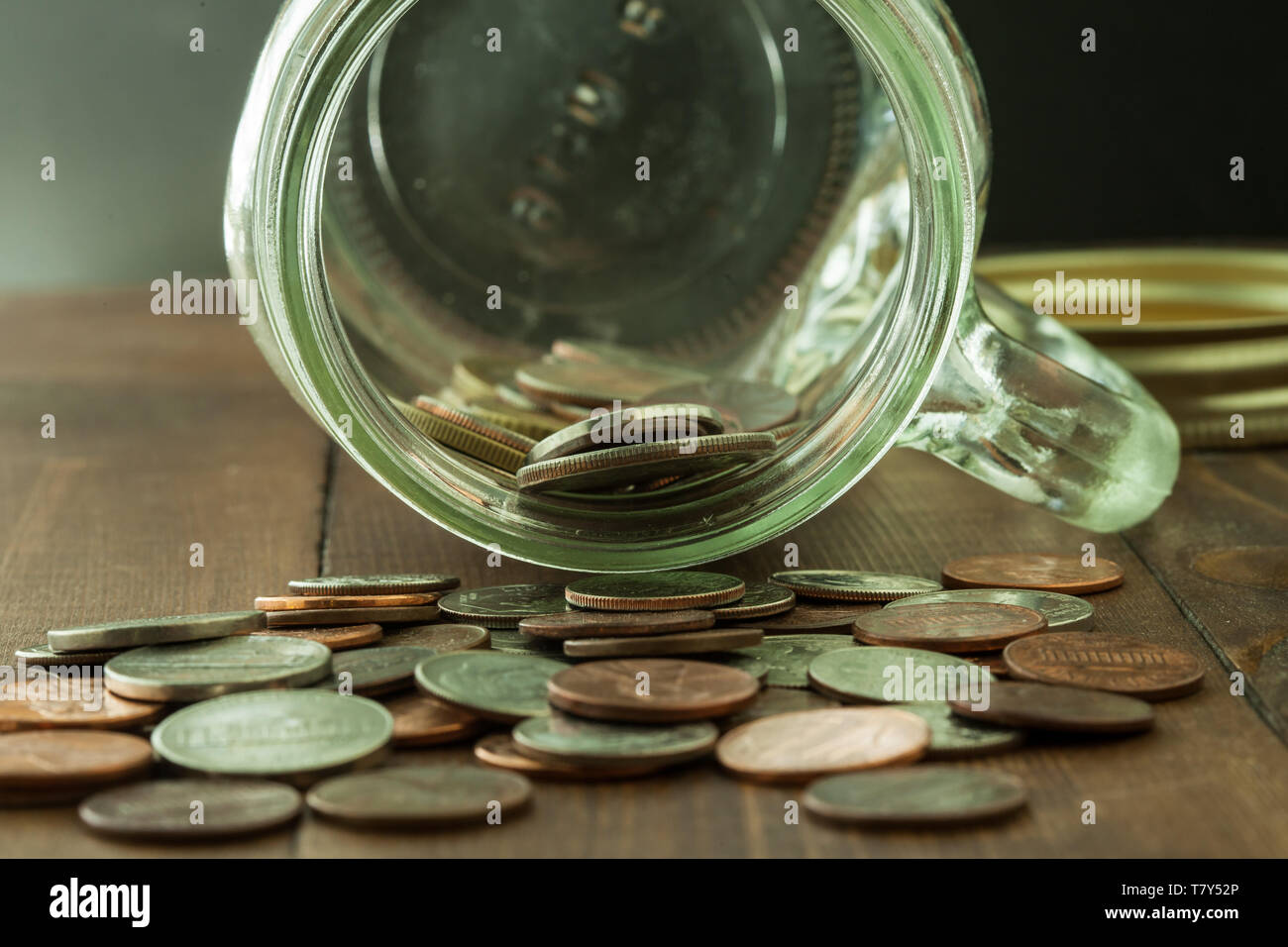 Geld im Glas auf Holztisch Stockfoto