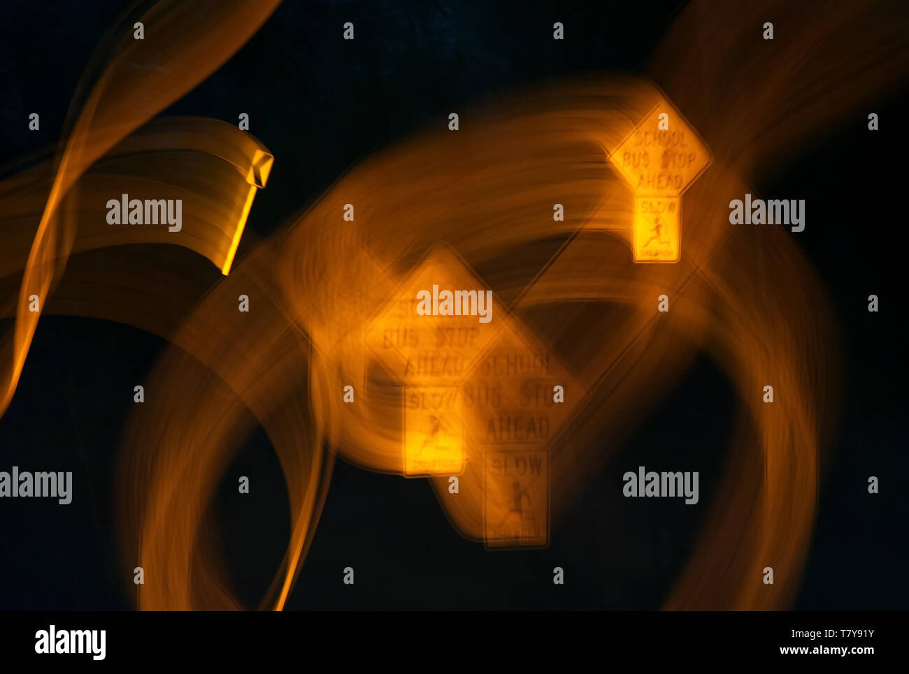 Verzerrte Schule Bushaltestelle und Kurve voraus Straßenschilder wie betrunken gesehen, betäubt, oder schläfrig Drivers. Stockfoto