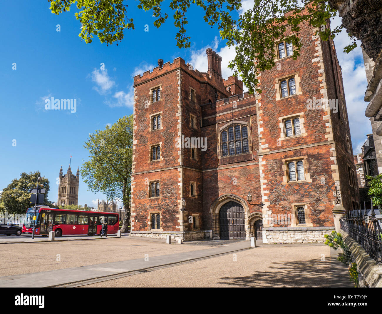 Lambeth Palace in London. Morton's Tower mit Parlament und red London Bus. Red brick Tudor Torhaus bildet den Eingang zum Lambeth Palace London UK Stockfoto