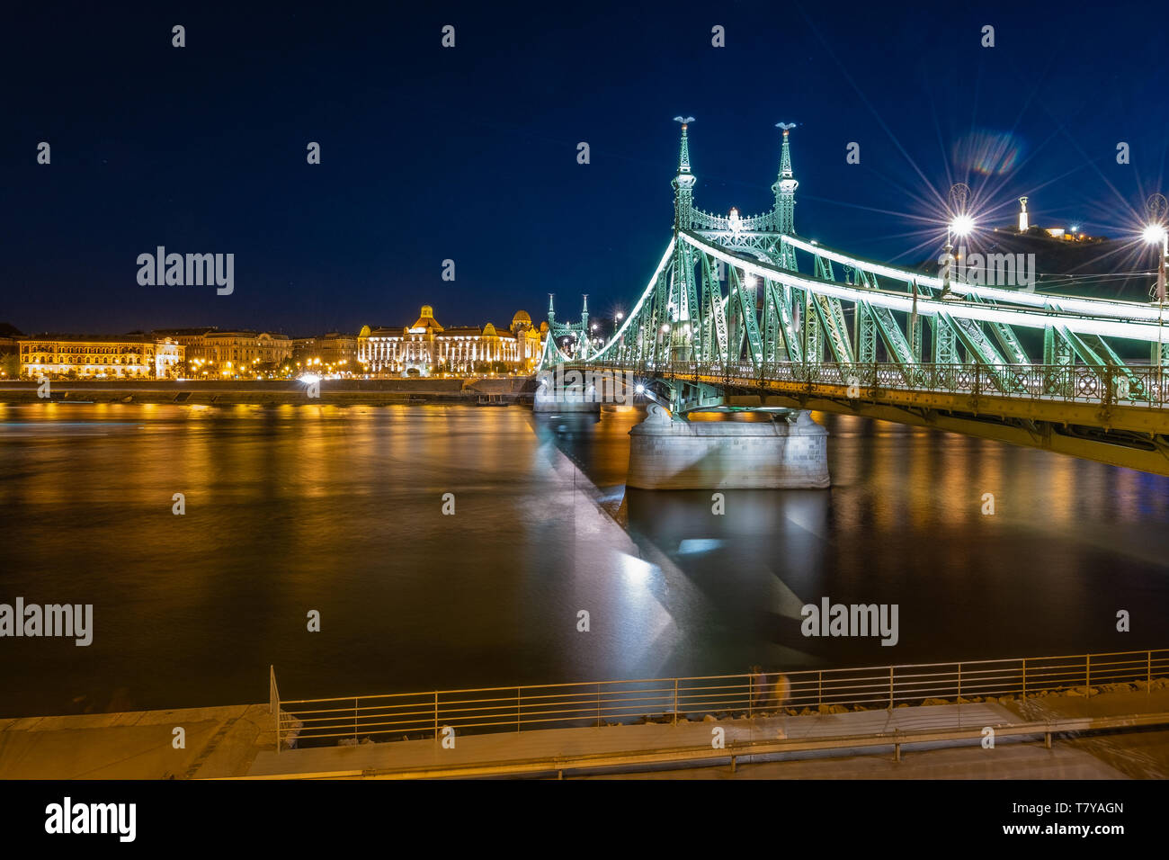 Die Freiheitsbrücke zabadság hid' Blick Richtung Buda mit Gellért Hotel und Hill, Freiheitsstatue, in Budapest Donau Riverside, Nacht. Stockfoto