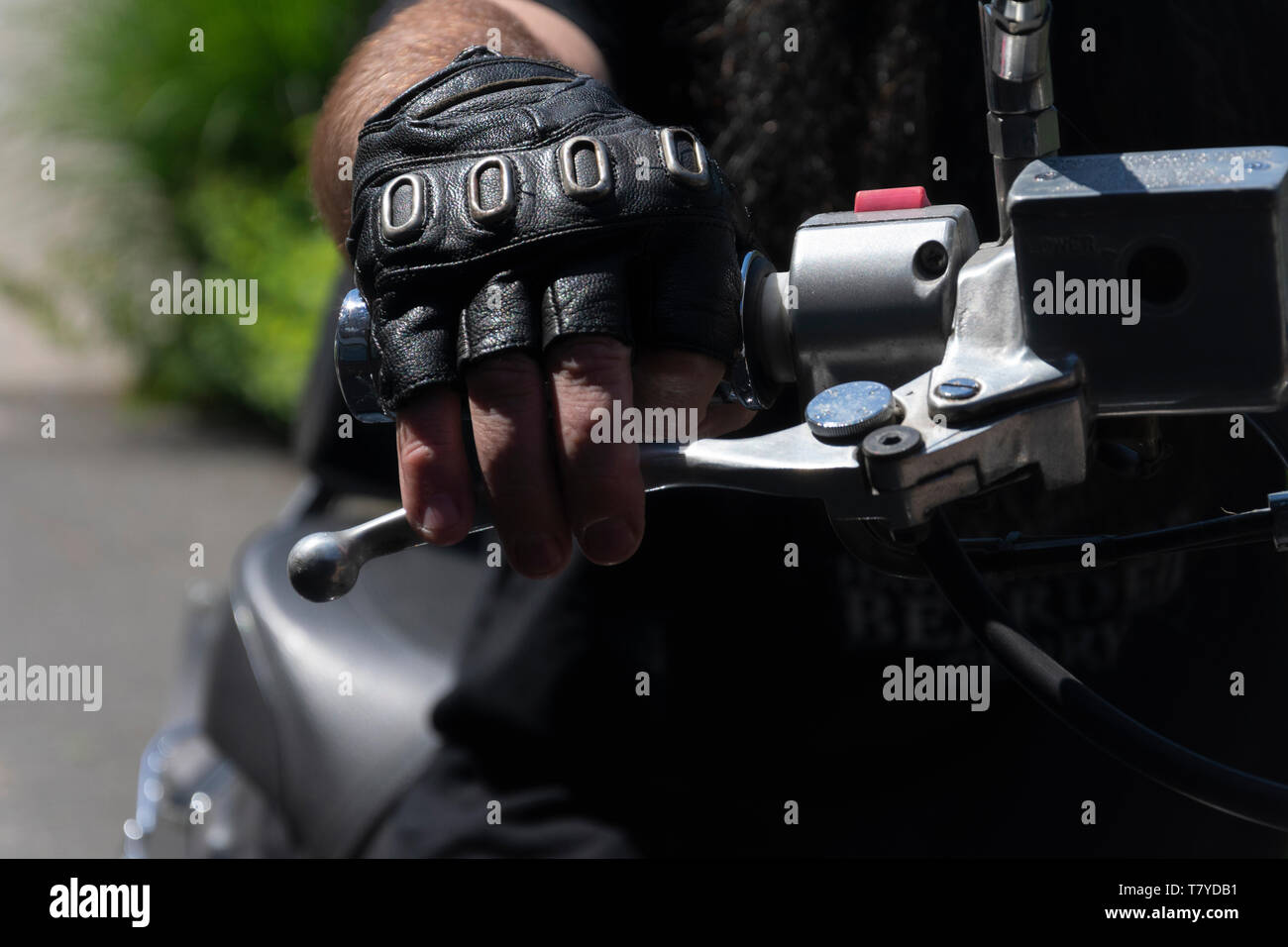 Mann mit fingerlose Lederhandschuhe seine Hand auf das Lenkrad lassen und nimmt der vorderen Bremse Stockfoto