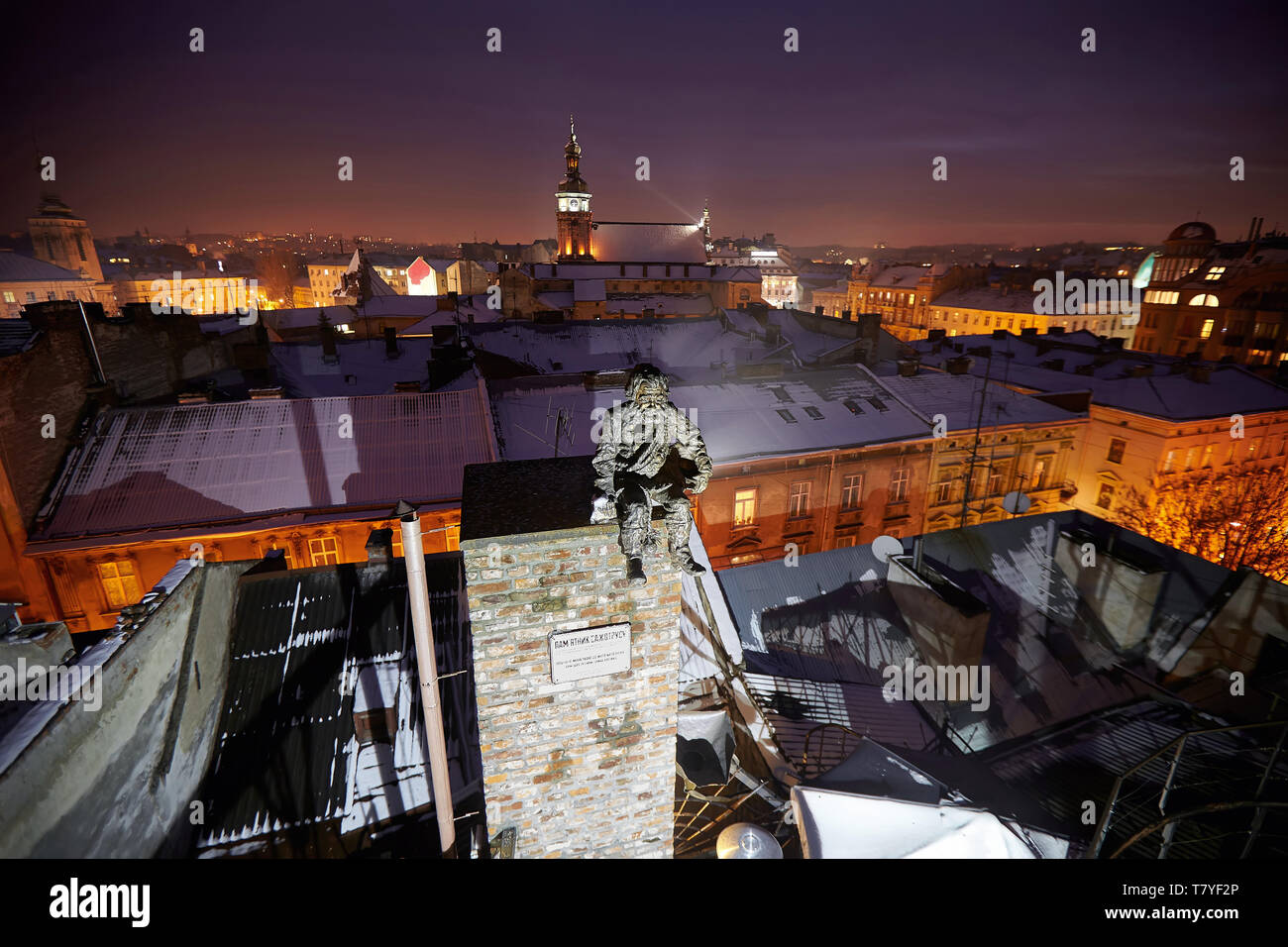 Skulptur ein Schornsteinfeger auf dem Dach des Hauses von Legenden, Winternacht, Lviv, Ukraine. Lemberg ist der attraktivste Ort für Touristen in der Ukraine Stockfoto