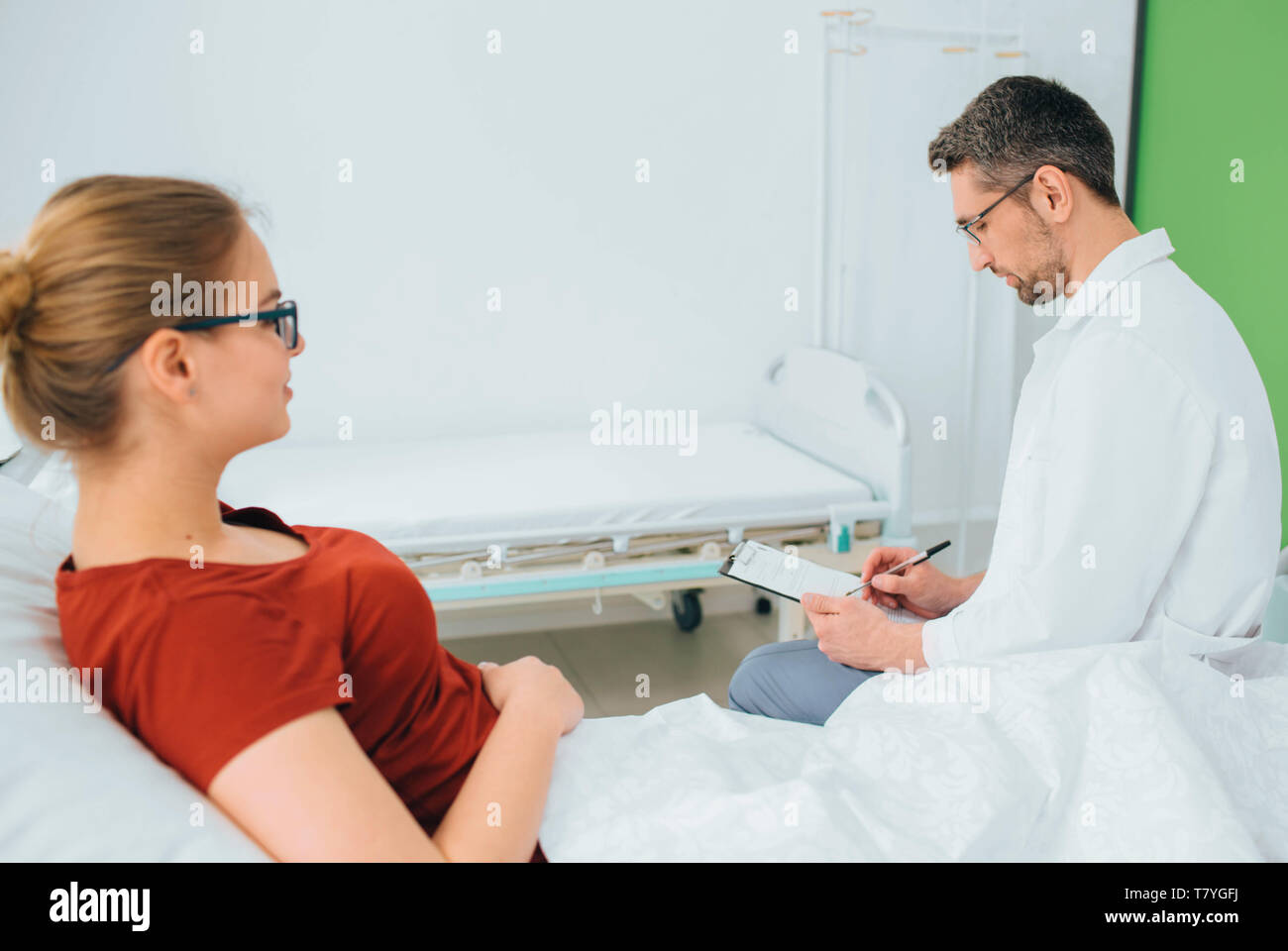 Arzt Beratung Patient im Krankenhaus Zimmer und durch einige Anmerkungen Stockfoto