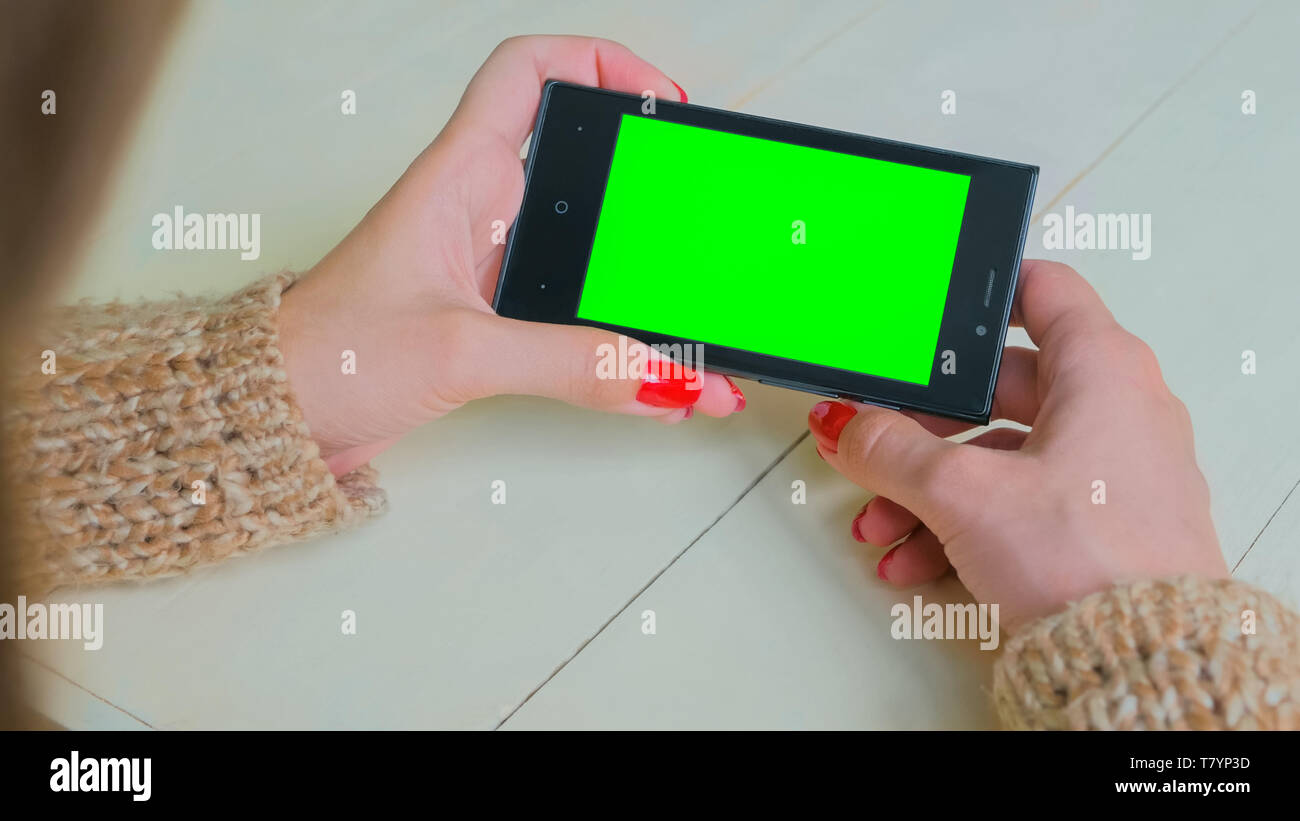 Frau Suchen bei Smartphones mit Green Screen Stockfoto