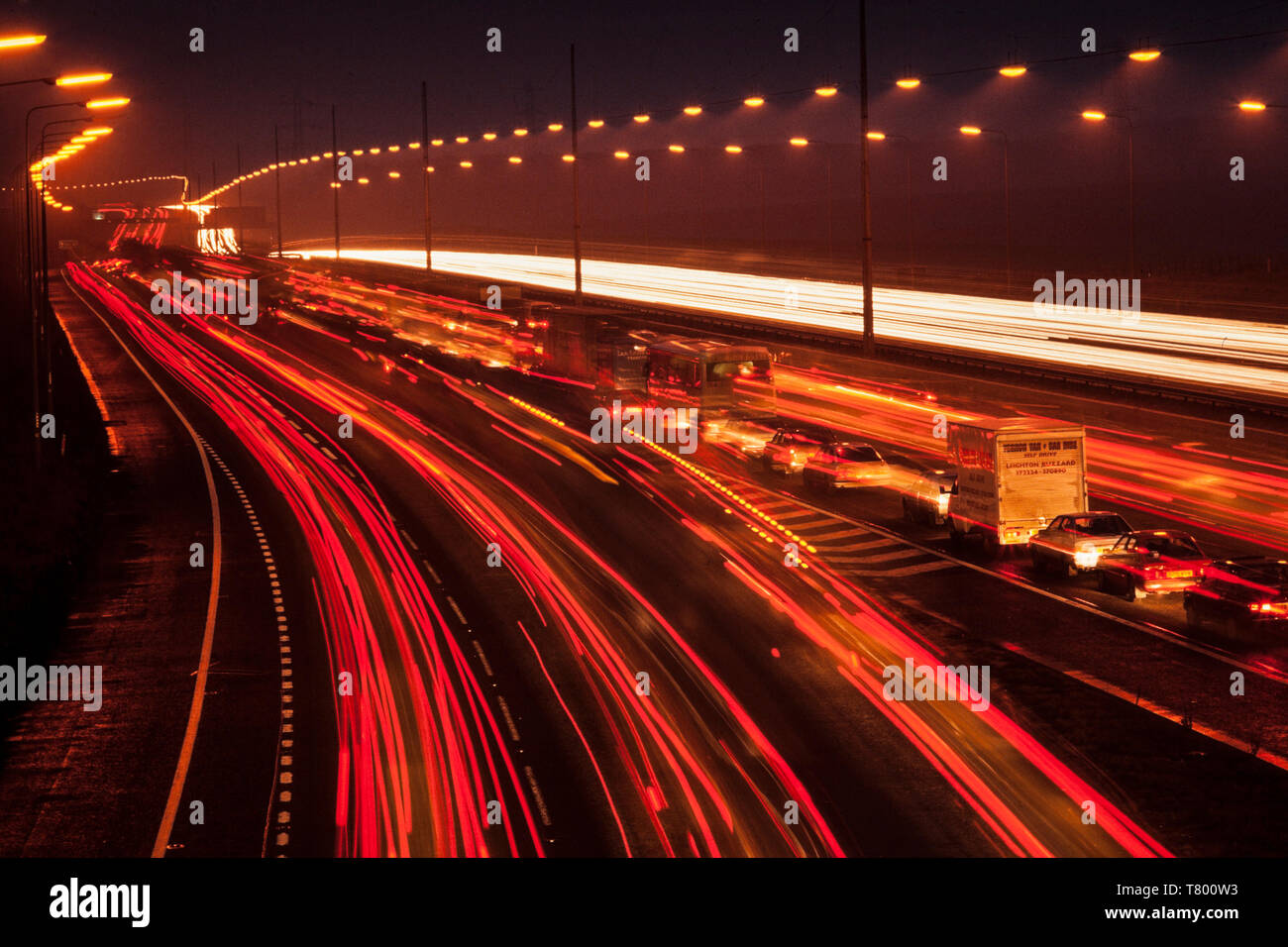UK abend Verkehr auf der Autobahn, kalte Winter Abend, Auto Scheinwerfer stream Vergangenheit Stockfoto