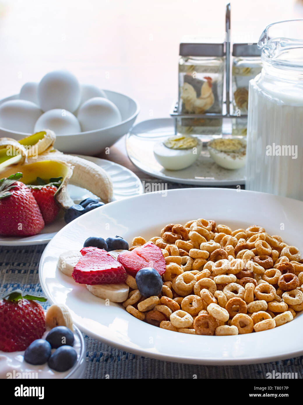 Eine Schüssel Hafer Müsli mit Obst, Milch, Eier und Joghurt als Teil einer ausgewogenen Frühstück. Stockfoto