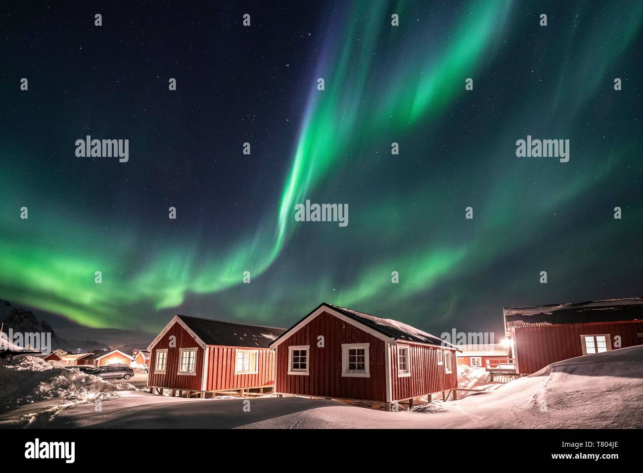 Nordlichter (Aurora Borealis) über Rorbuer Hütten im Winter, Hamnoy, Moskenesoya, Lofoten, Norwegen Stockfoto