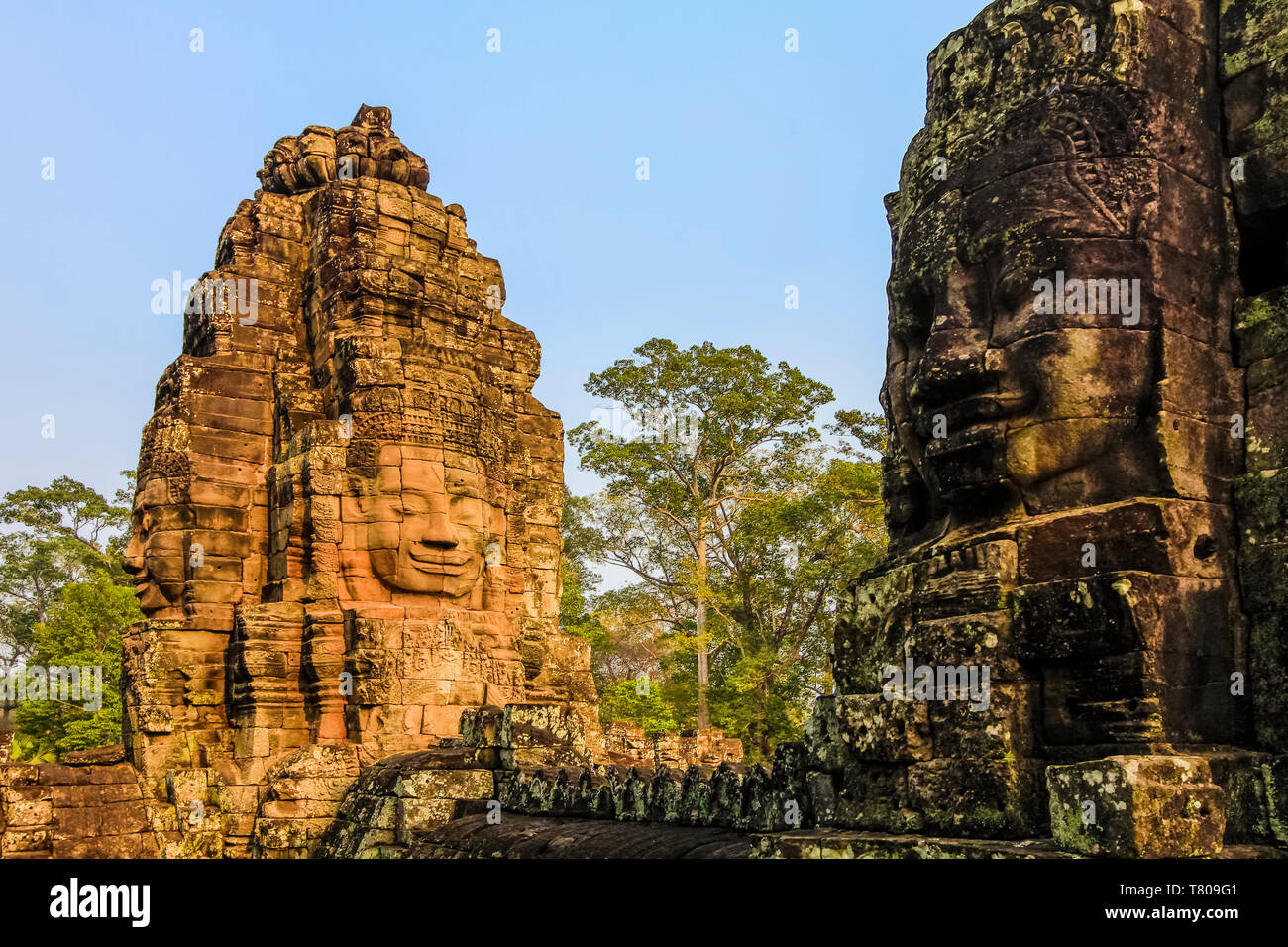 Türme und drei der 216 lächelnden Gesichtern aus Sandstein im 12. Jahrhundert Bayon Tempel in Angkor Thom ummauerten Stadt, Angkor, UNESCO, Siem Reap, Kambodscha, Asien Stockfoto