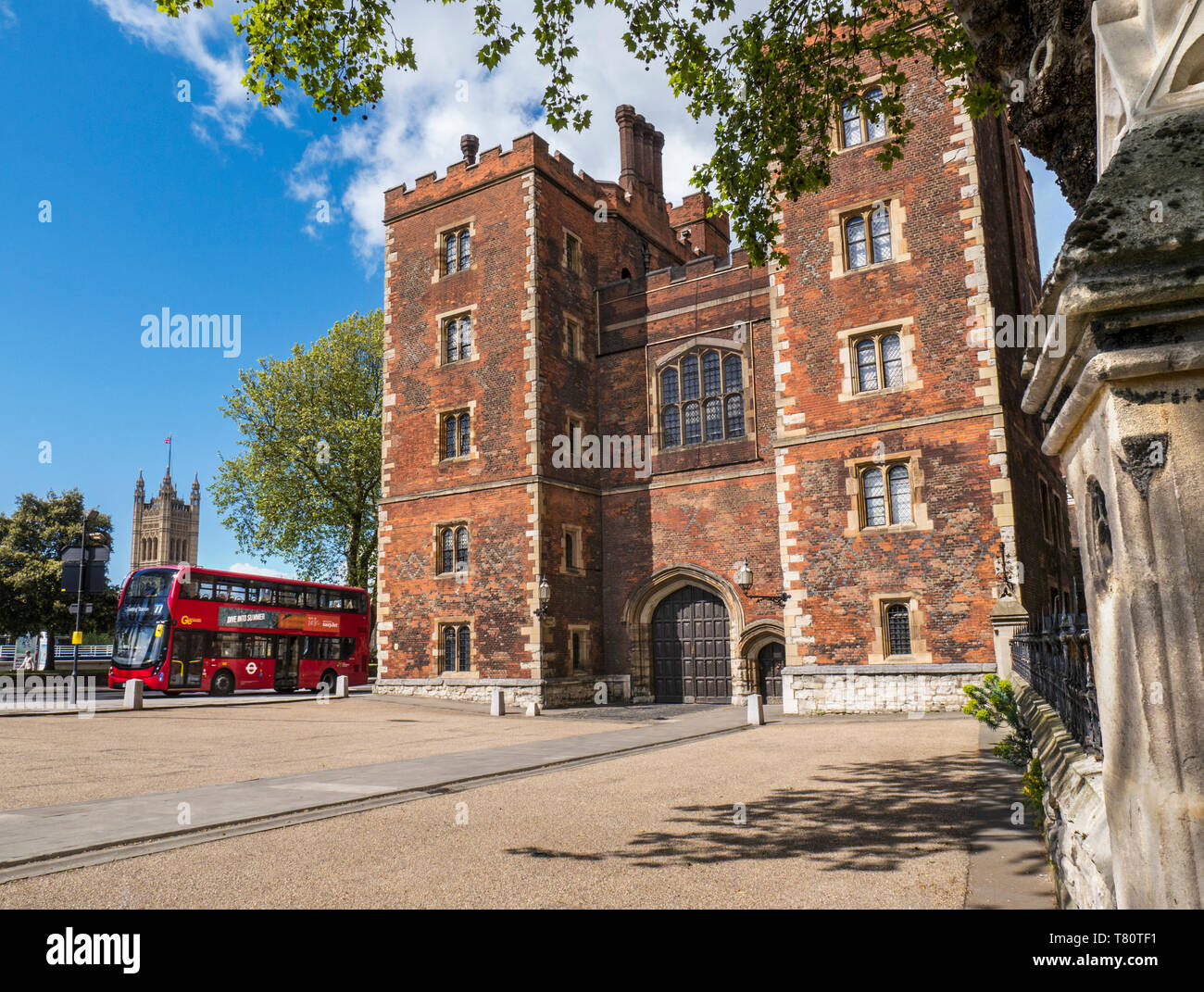 Lambeth Palace in London. Morton's Tower mit Parlament und red London Bus. Red brick Tudor Torhaus bildet den Eingang zum Lambeth Palace London UK Stockfoto