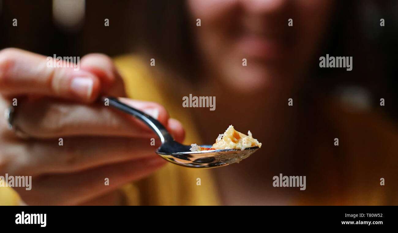 Boston, MA/USA, 18. April 2019: Frau mit ein bisschen Dessert auf einem Löffel für den Betrachter Stockfoto