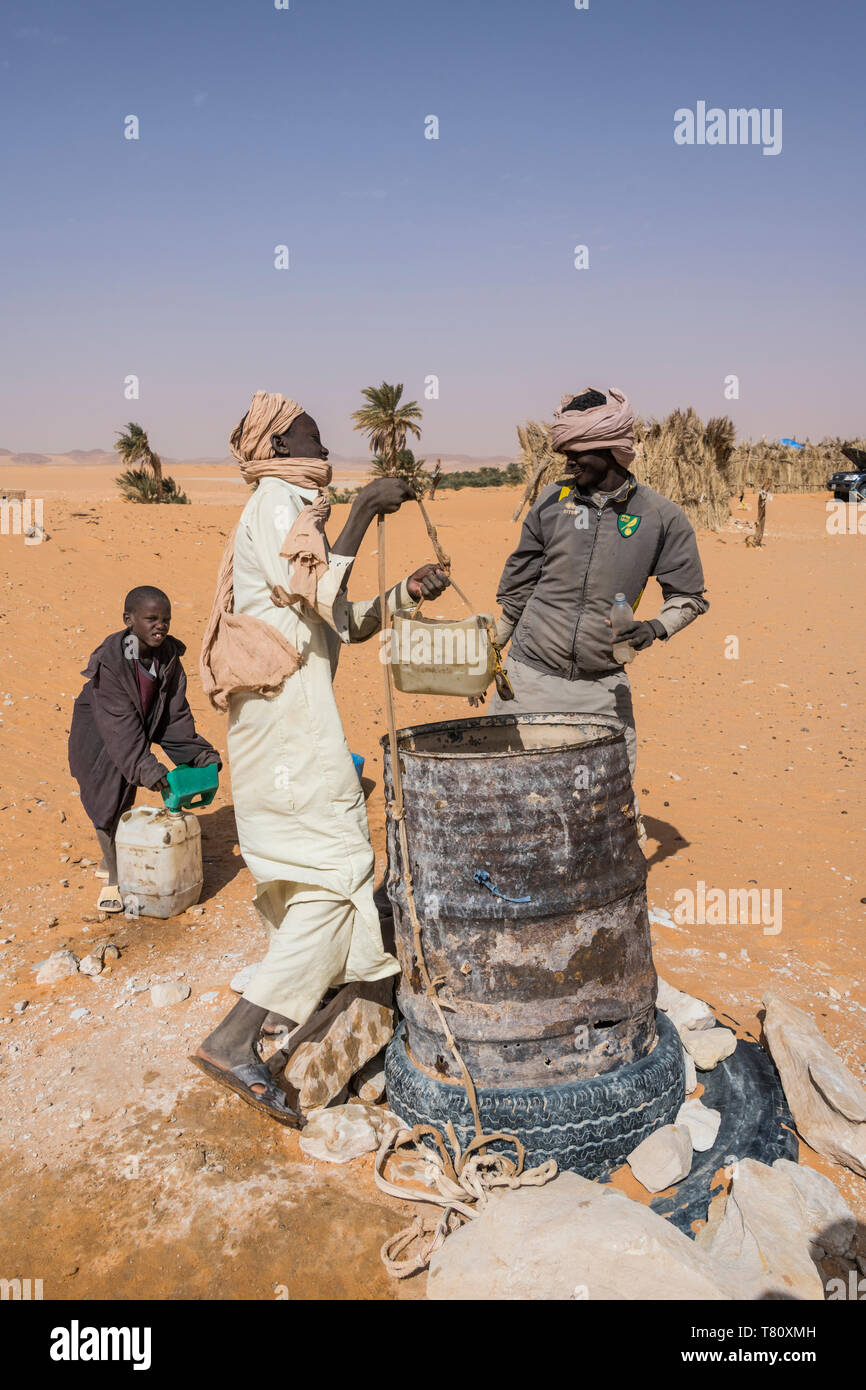 Lokalen jungen Zeichnung Wasser aus ihren Brunnen in der Wüste zwischen Ounianga Kebir und Faya, Norden des Tschad, Afrika Stockfoto