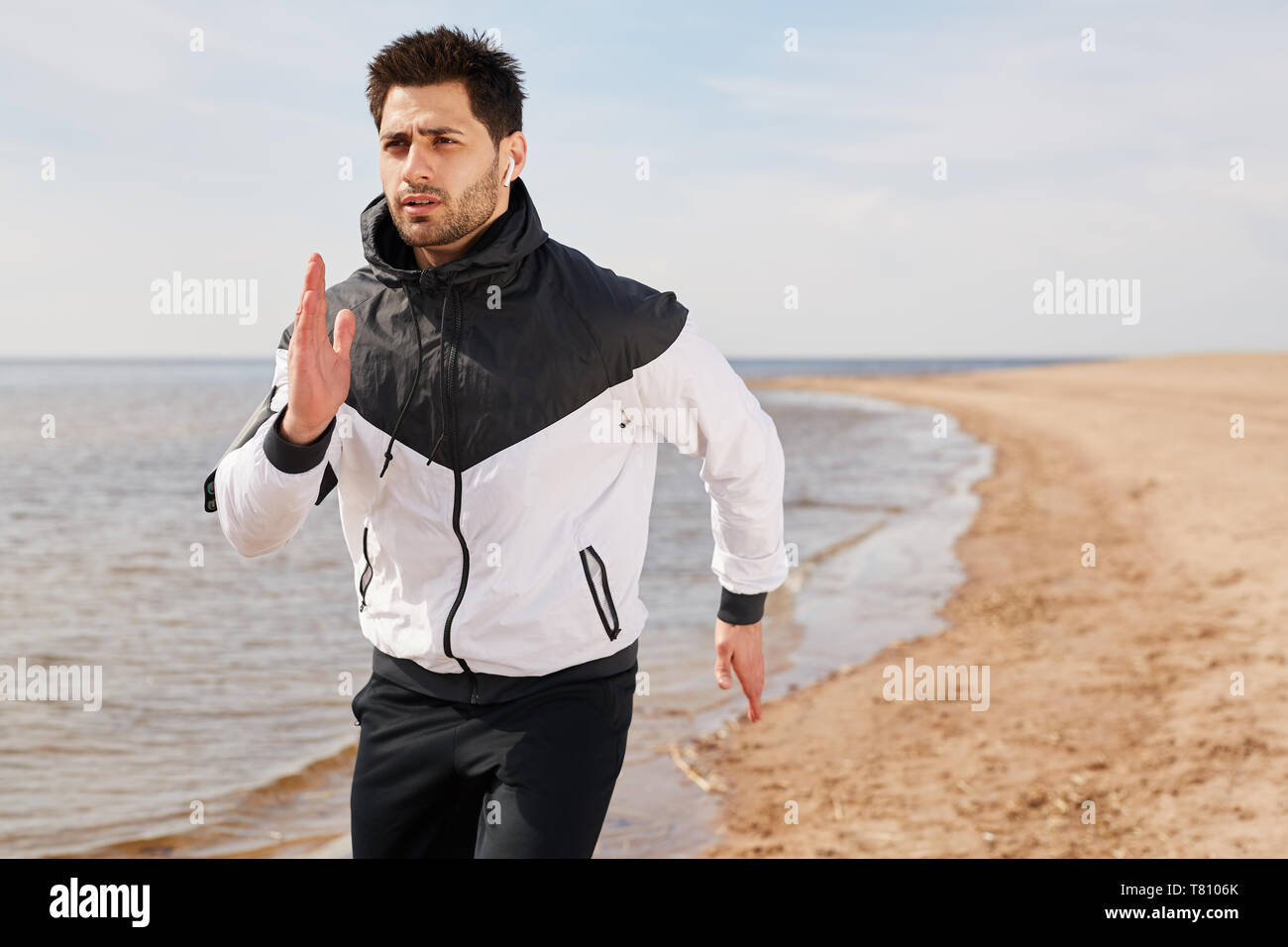 Guy Jogging am Strand Stockfoto