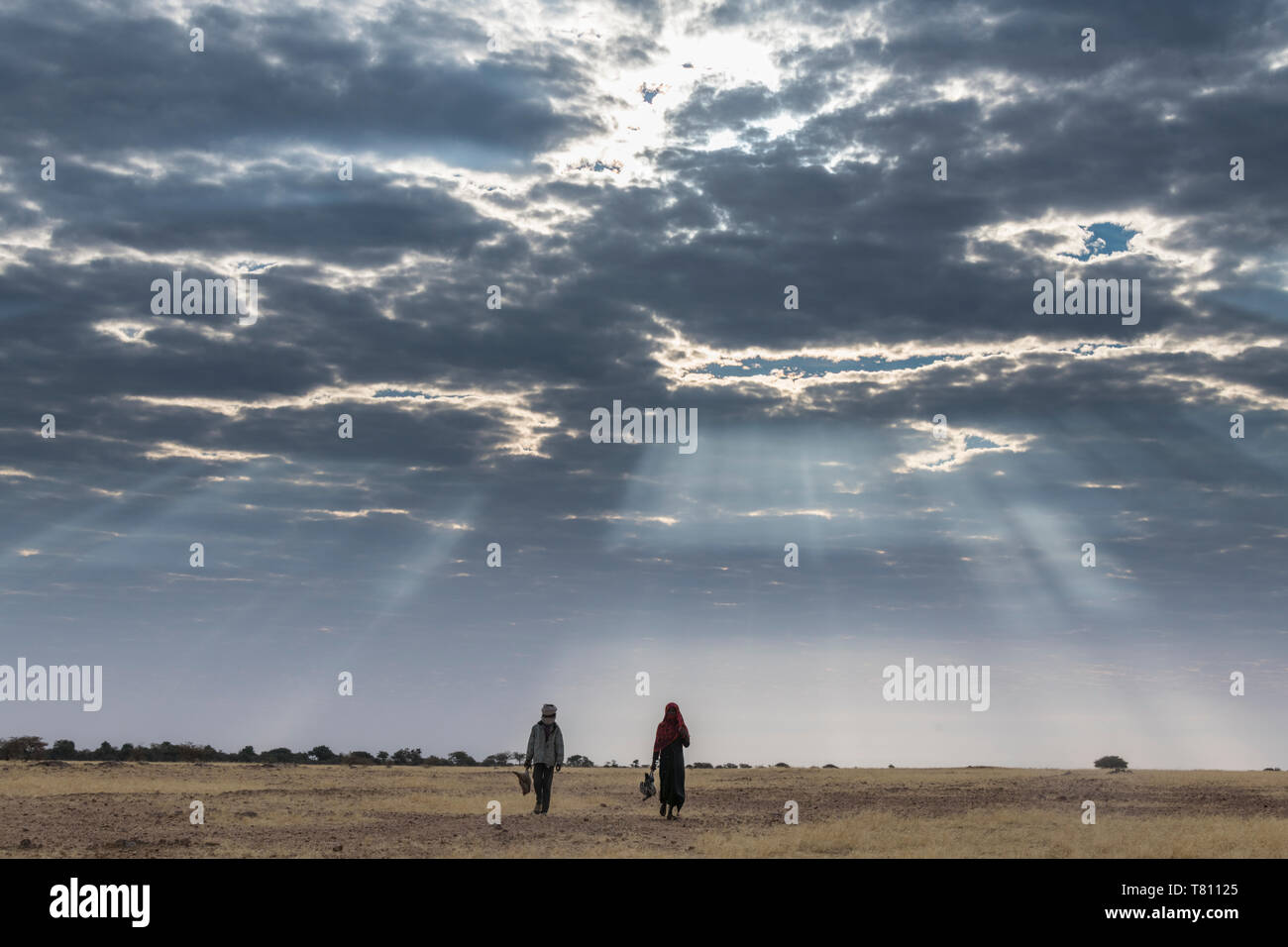Bedouin Kinder gehen unter einem dramatischen Himmel im Sahel, Tschad, Afrika Stockfoto