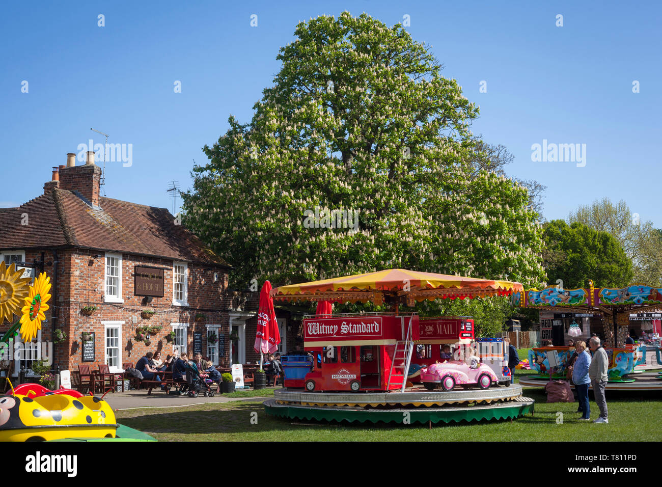 Ein bunter Jahrmarkt Kreisverkehr mit einer Rosskastanie Baum hinter auf der Kinecroft in Wallingford, Oxfordshire. Stockfoto