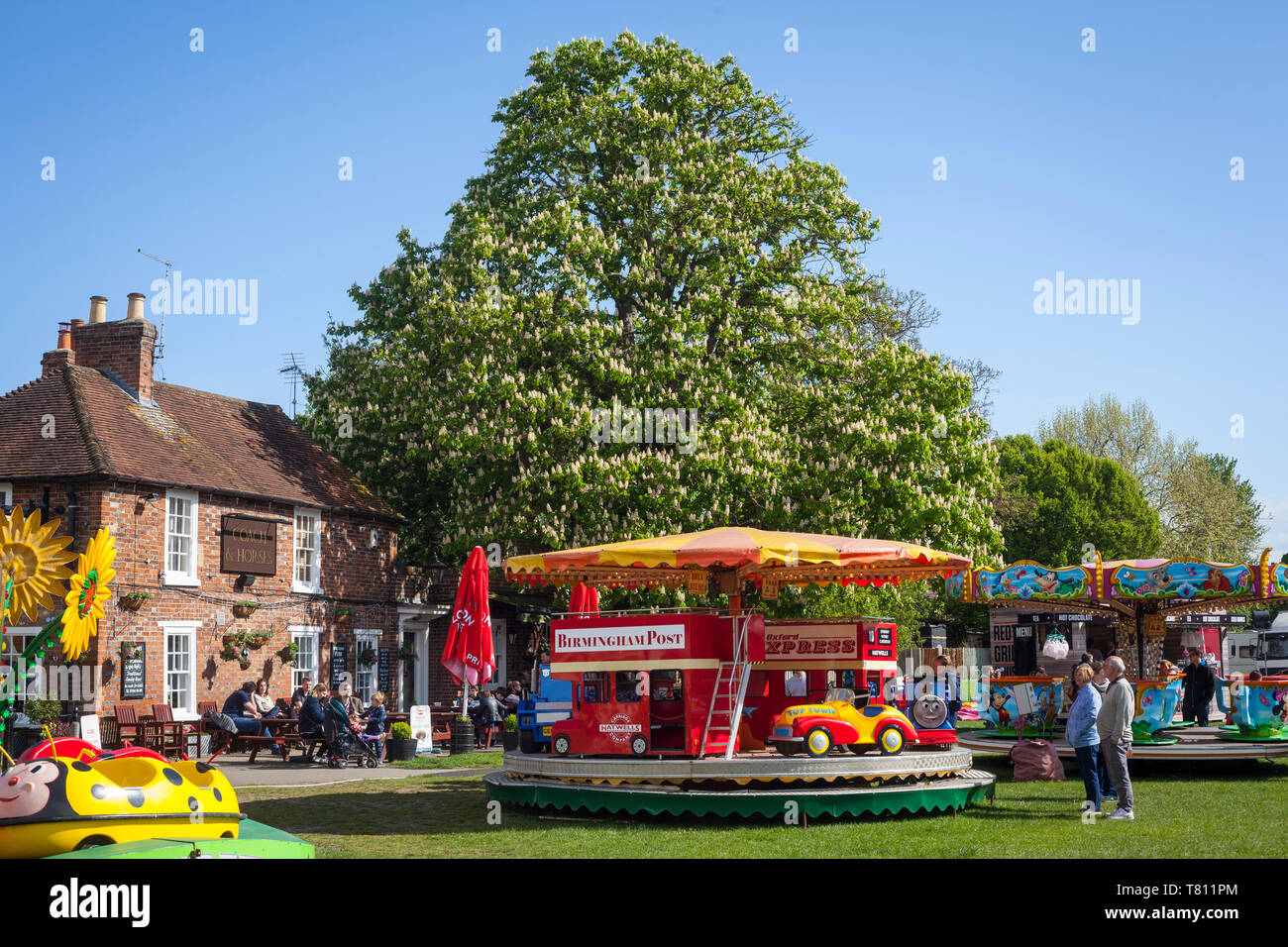 Ein bunter Jahrmarkt Kreisverkehr mit einer Rosskastanie Baum hinter auf der Kinecroft in Wallingford, Oxfordshire. Stockfoto
