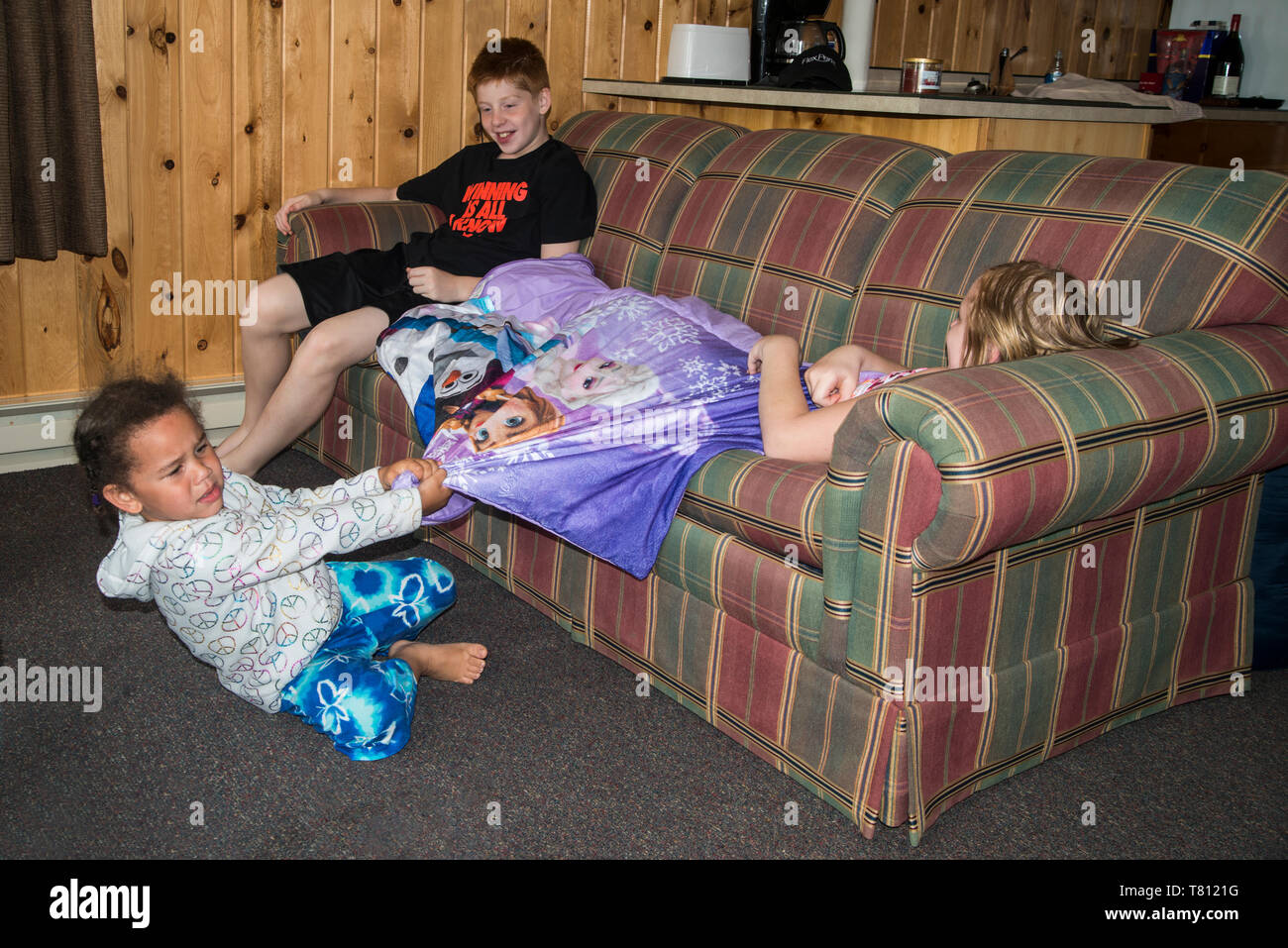 Naytahwaush; Minnesota. Ein junges Kind, das versucht ihr Liebling Decke zurück von ihrer Schwester zu erhalten, während ihr Bruder Uhren. Stockfoto