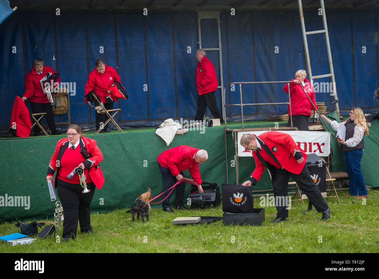 Mitglieder des Phoenix Brass Band in hellen roten Jacken Packen nach ihrer Leistung an ein Land zeigen. Stockfoto