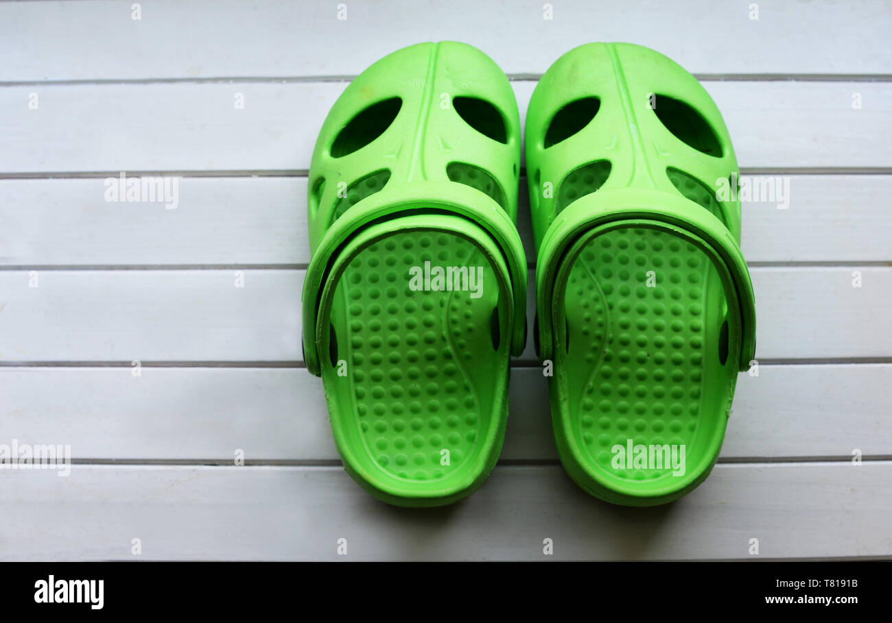 Baby Schuhe crocs Grün auf Weiß Holz- Hintergrund Stockfotografie - Alamy