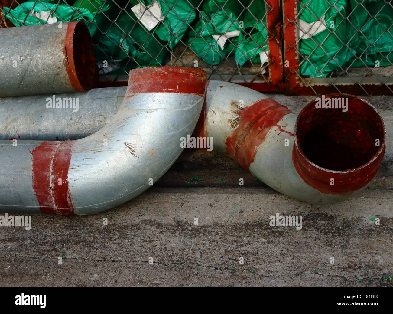 Nahaufnahme eines Teils der großen metallischen Rohrleitungen auf Betonboden Stockfoto