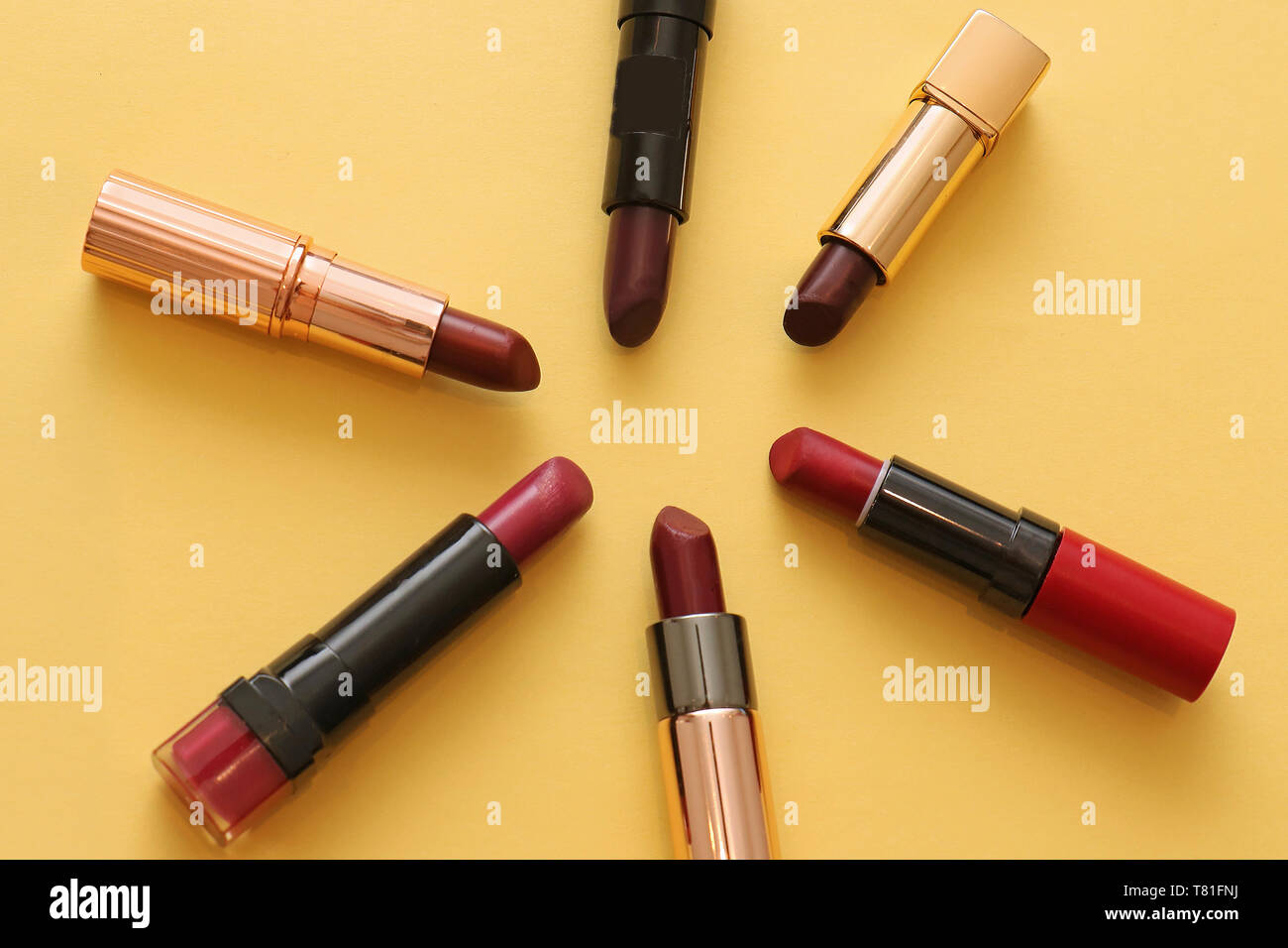 Schattierungen von rot Lippenstift make up Rohre auf gelbem Hintergrund Stockfoto