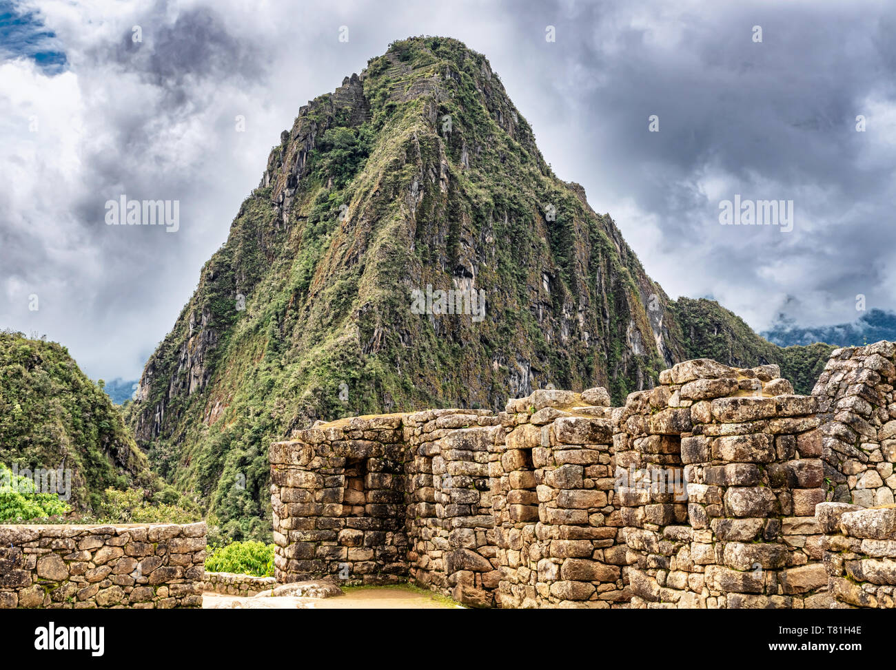 Gebäude, Häuser Strukturen in Inka Stadt von Machu Picchu in Peru. Wayna, Huayna Picchu Mountain Peak im Hintergrund. Stockfoto