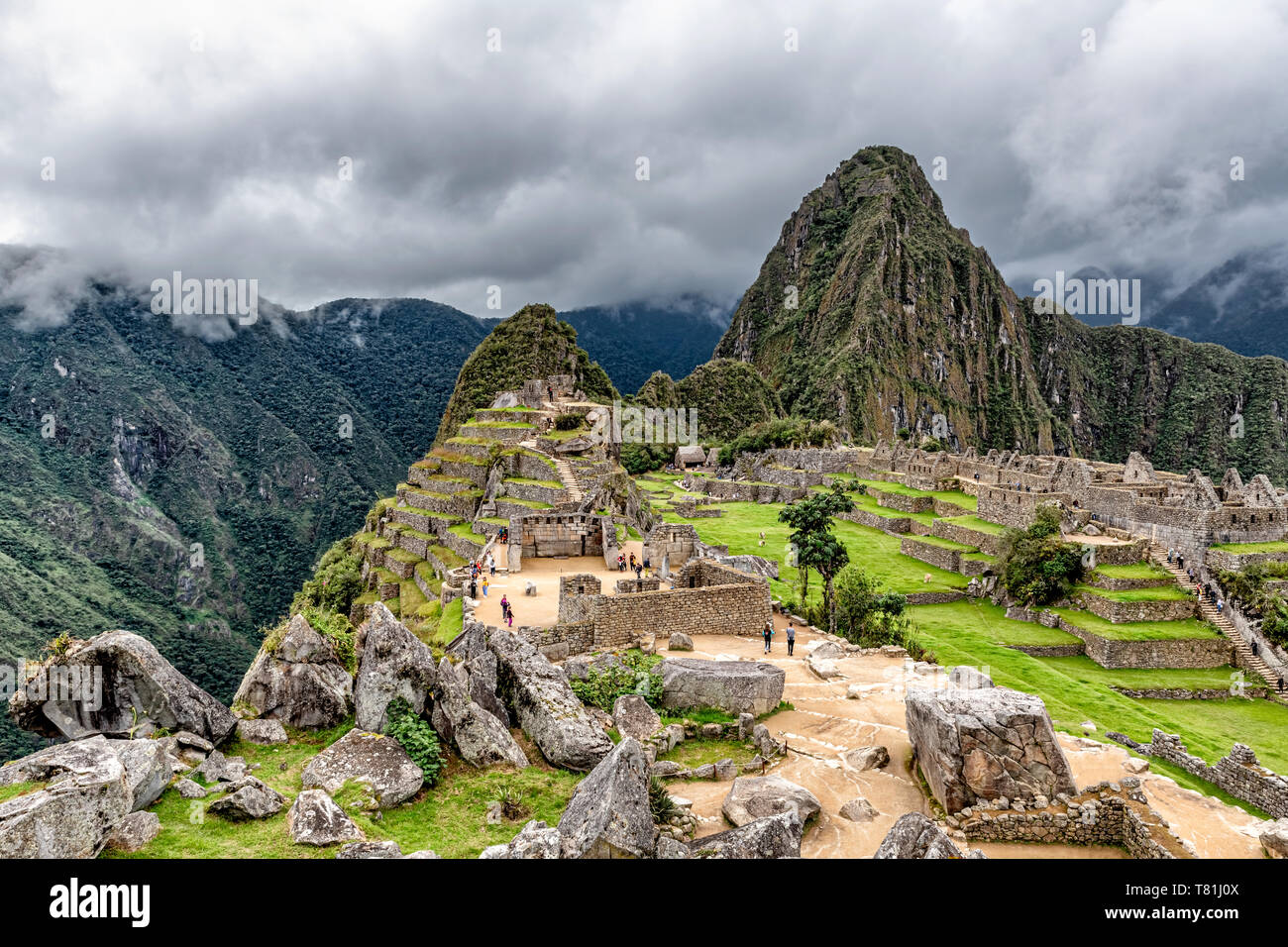 Gebäude und Häuser Strukturen in Inka Stadt von Machu Picchu in Peru. Wayna, Huayna Picchu Mountain Peak im Hintergrund. Stockfoto