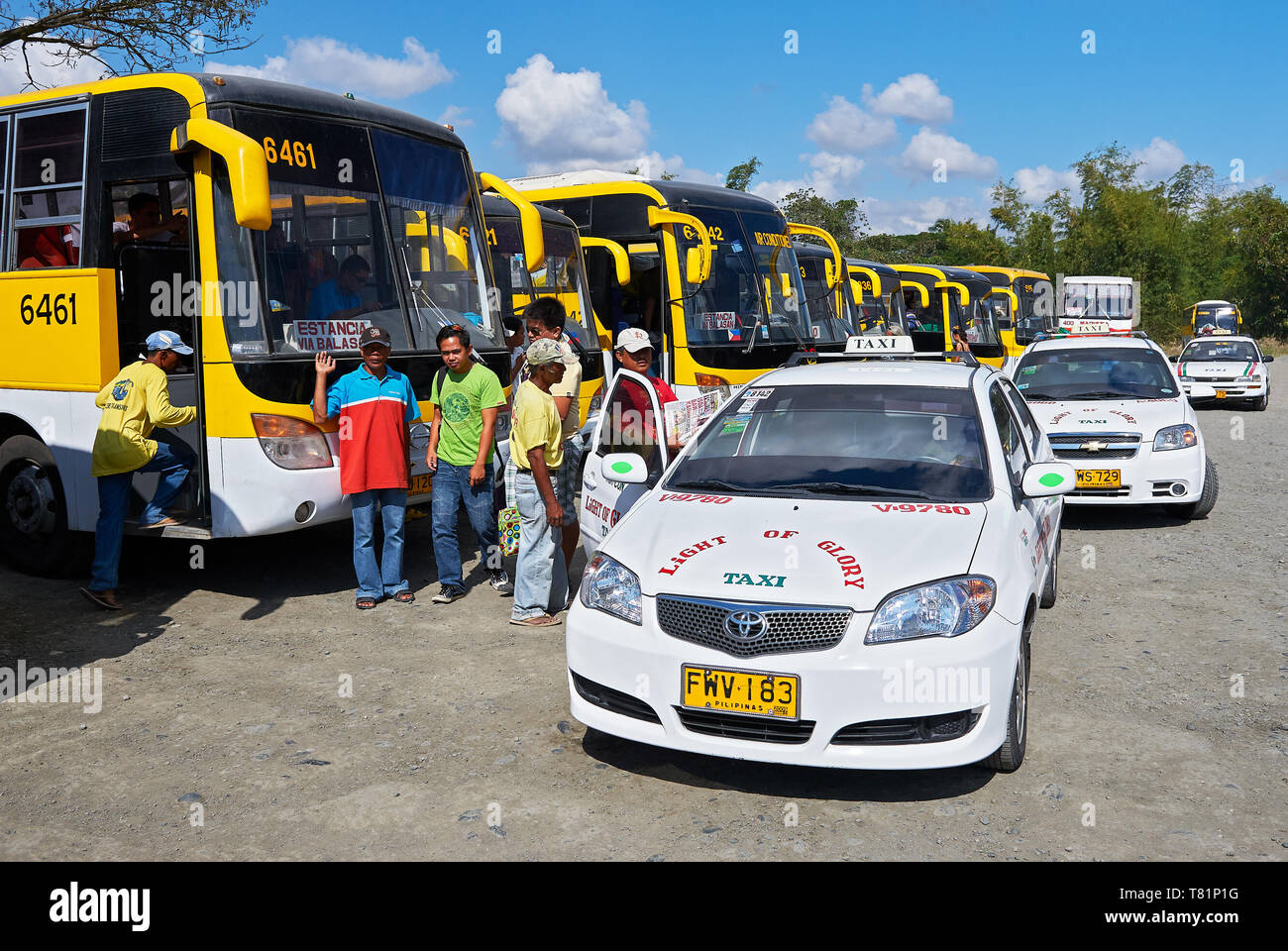 Iloilo City, Provinz Iloilo, Philippinen - 27. Februar 2010: Busse und Taxis in einer Reihe zusammen mit Passagieren am Tagbak Bus Terminal Stockfoto