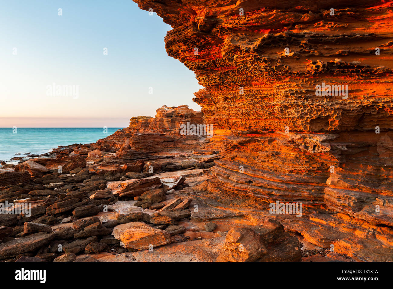 Glühende Felsen bei Sonnenaufgang in der Broome Roebuck Bay. Stockfoto