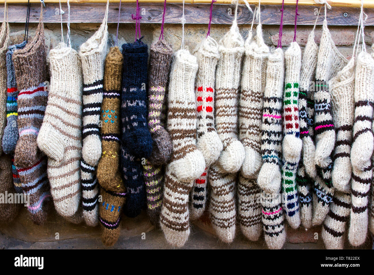 Neue gestrickte Wollsocken in verschiedenen Farben und Ornamente in einer Reihe hängen Stockfoto