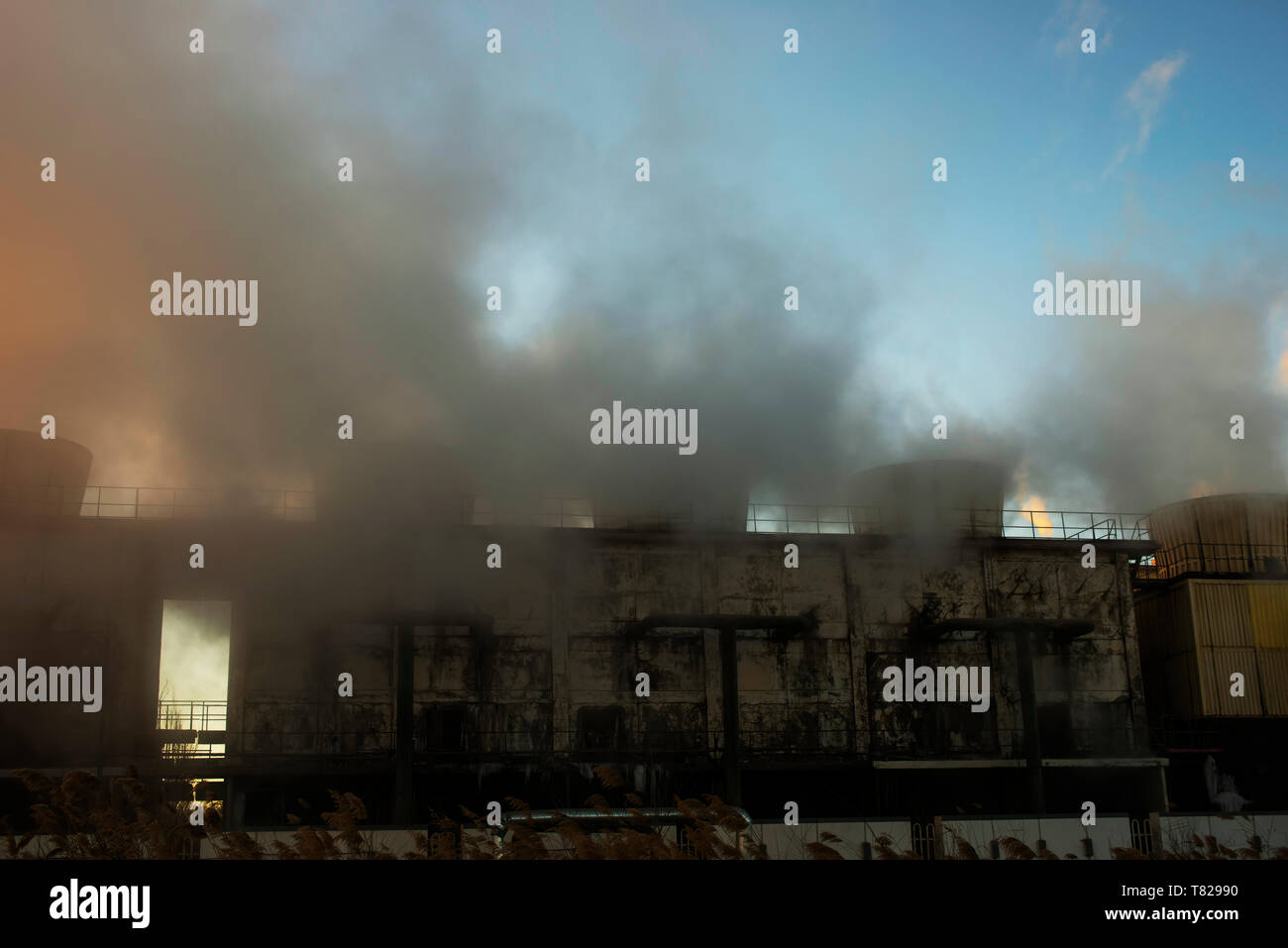 Chemieanlage Kühltürme Dampf bei Sonnenaufgang im Winter. Stockfoto