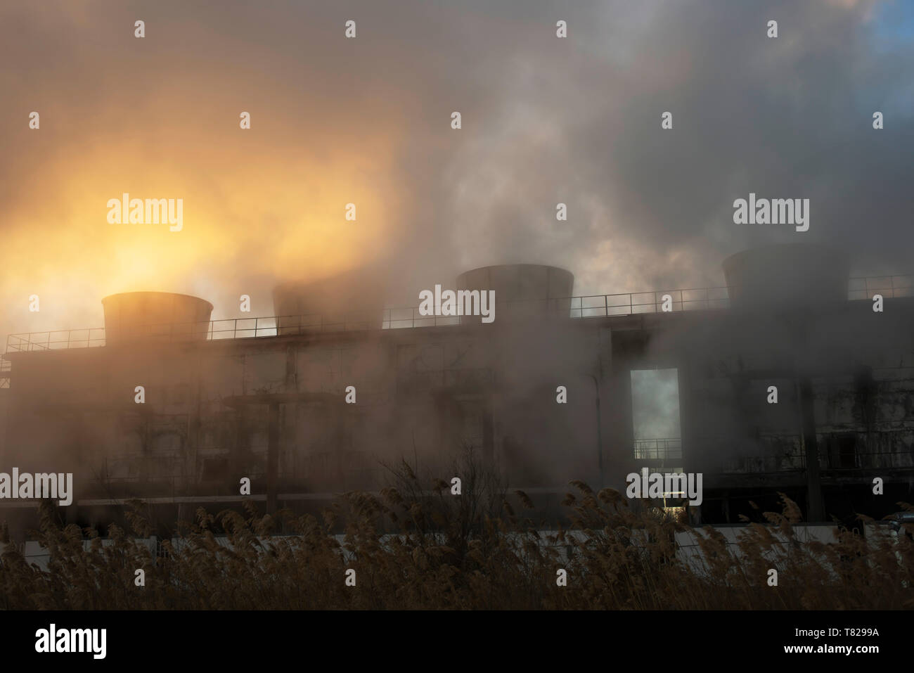 Chemieanlage Kühltürme Dampf bei Sonnenaufgang im Winter. Stockfoto