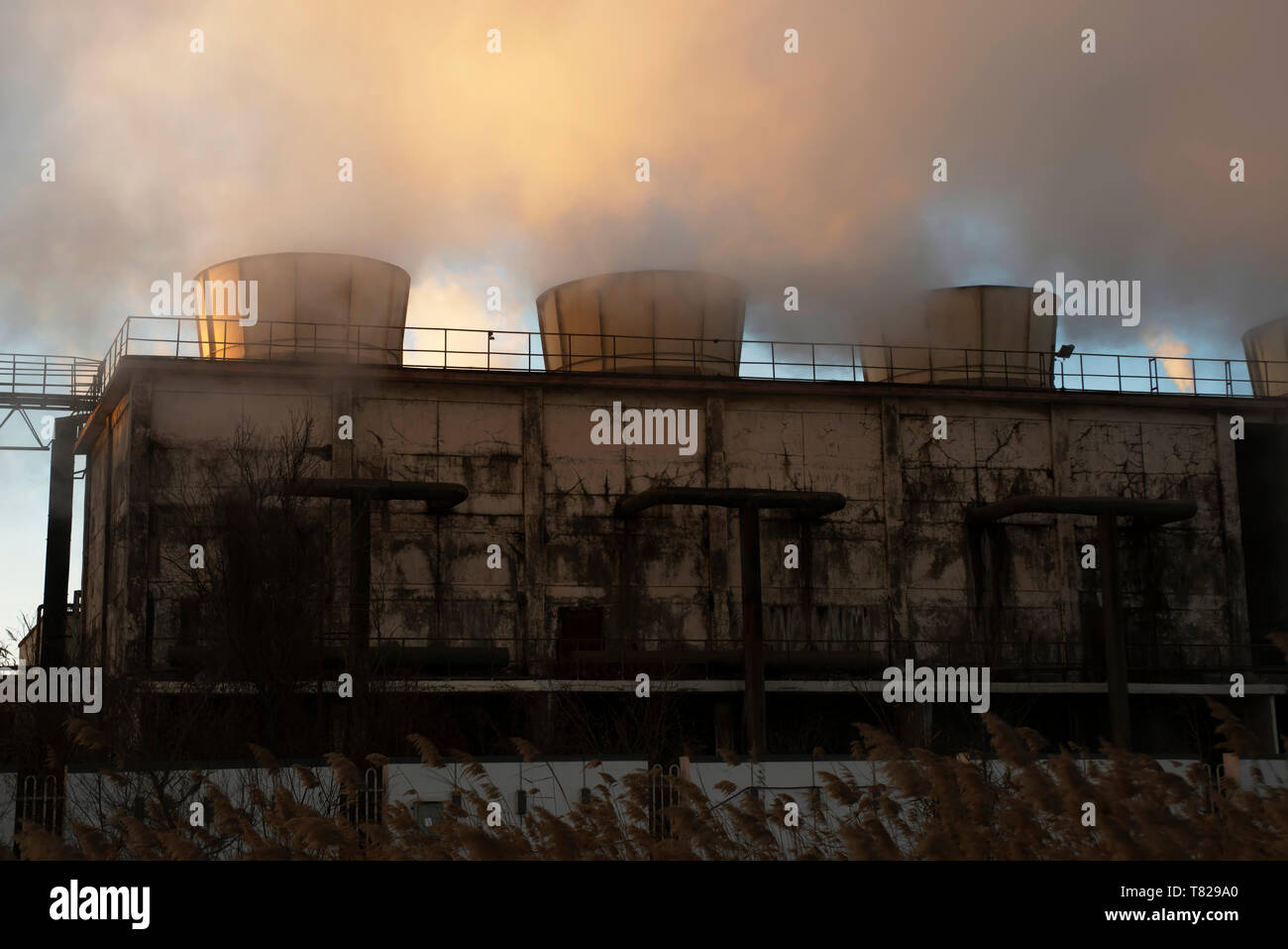 Chemieanlage Kühltürme Dampf bei Sonnenaufgang im Winter. Stockfoto