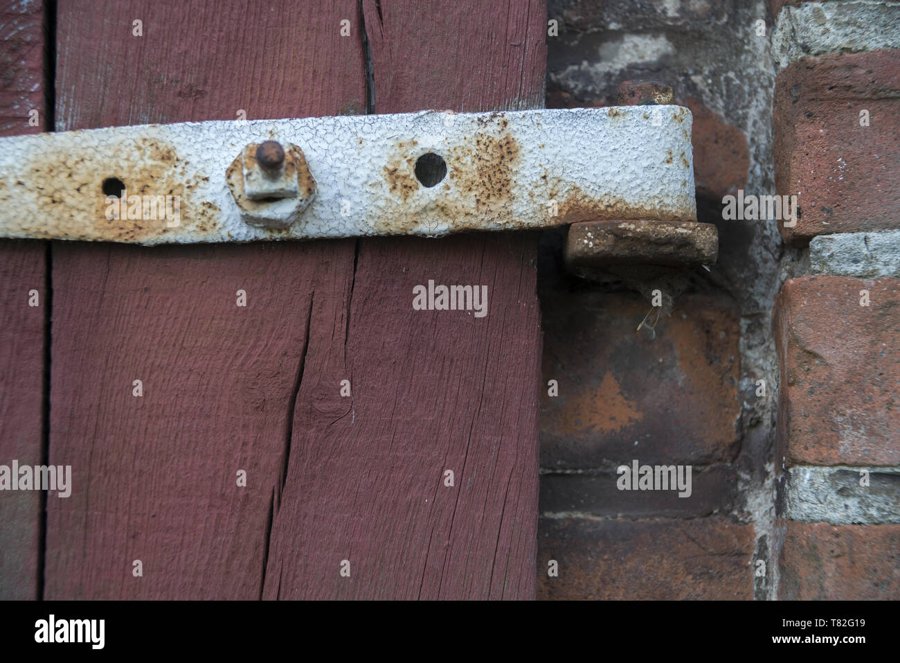 Das Fragment einer alte Holztür mit einer rostigen Scharniere. Ein Fragment einer alten Holztür mit einem rostigen Scharnier. Fragment starych drzwi z zawiasą. Stockfoto