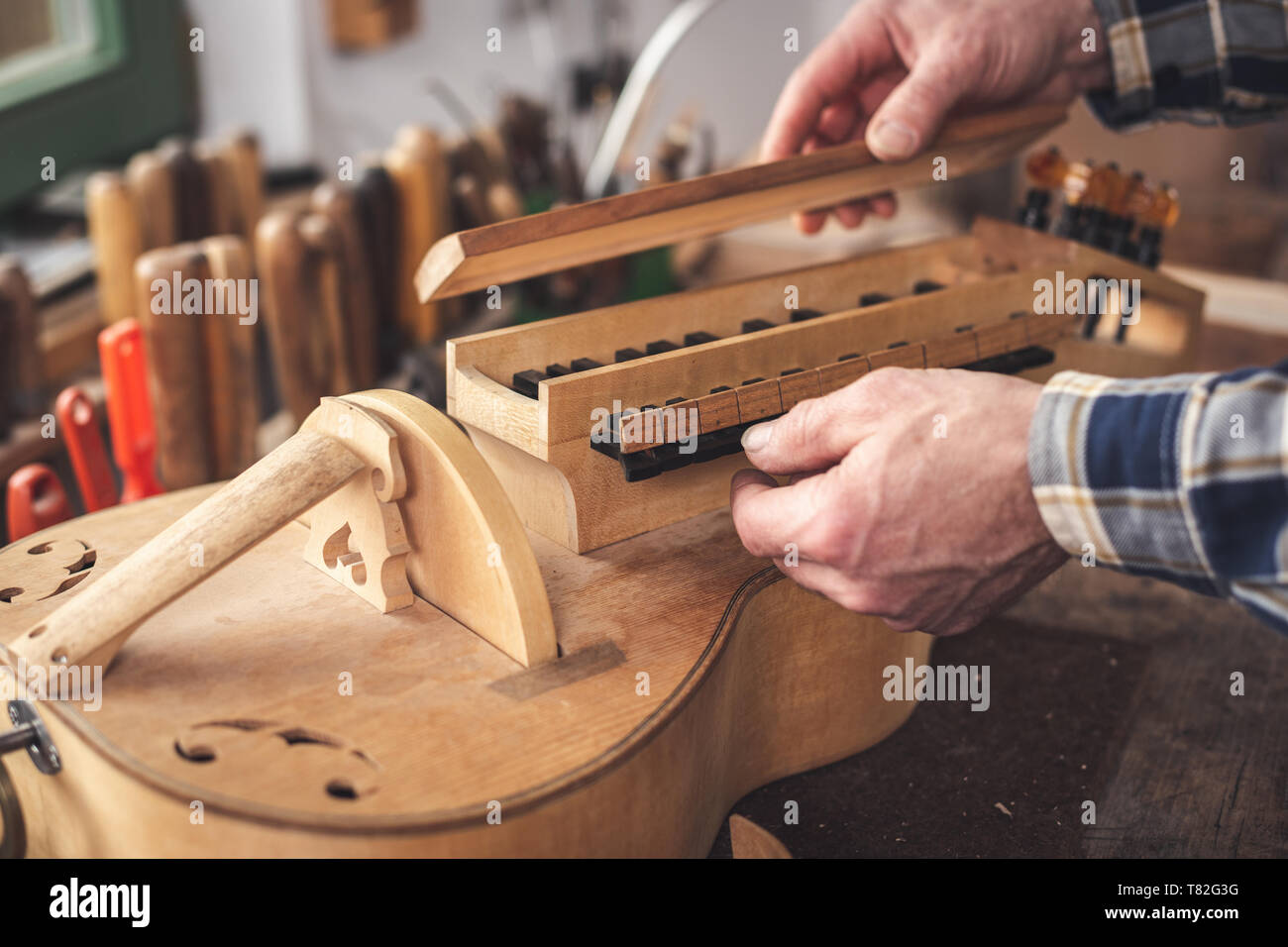 Hände von einem instrumentenbauer Arbeiten auf einer Drehleier Stockfoto