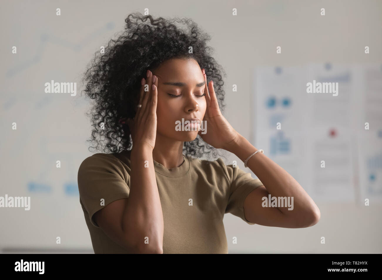 Erschöpft schwarze Frau Arbeiter massage Tempel in Kopfschmerzen Stockfoto