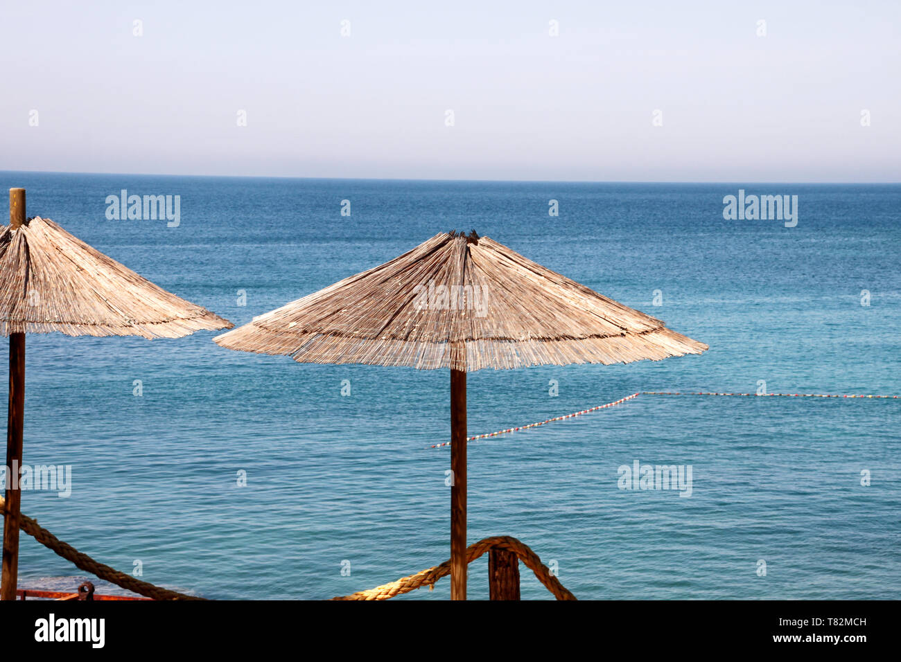 Lonely wicker Sonnenschirm am Strand am Mittelmeer. Natürliche Bambus  Sonnenschirme und Sommer Sonnenschirm Sonnenschirm am Ocean Beach. Große  Sonnenschirme Stockfotografie - Alamy