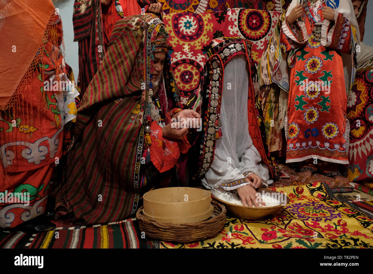 Usbekische Braut mit traditioneller kokoschnik tillya-kosh oder tilla kosh Braut Stirndekoration mit einem gauzy Schleier bedeckt, um das Gesicht der Braut vor indiskreten Augen und Seide bestickt Kostüm im Surkhandarya-Stil in der Stadt Jarkurgan in Surkhandarya oder Surxondaryo Region in Usbekistan zu verstecken Stockfoto