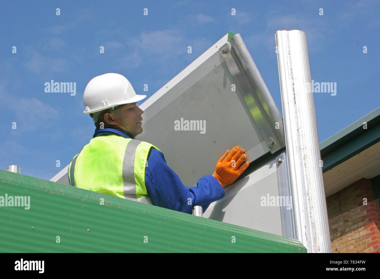 Ein Arbeiter versammelt eine akustische Barriere system Baulärm zu enthalten. Stockfoto
