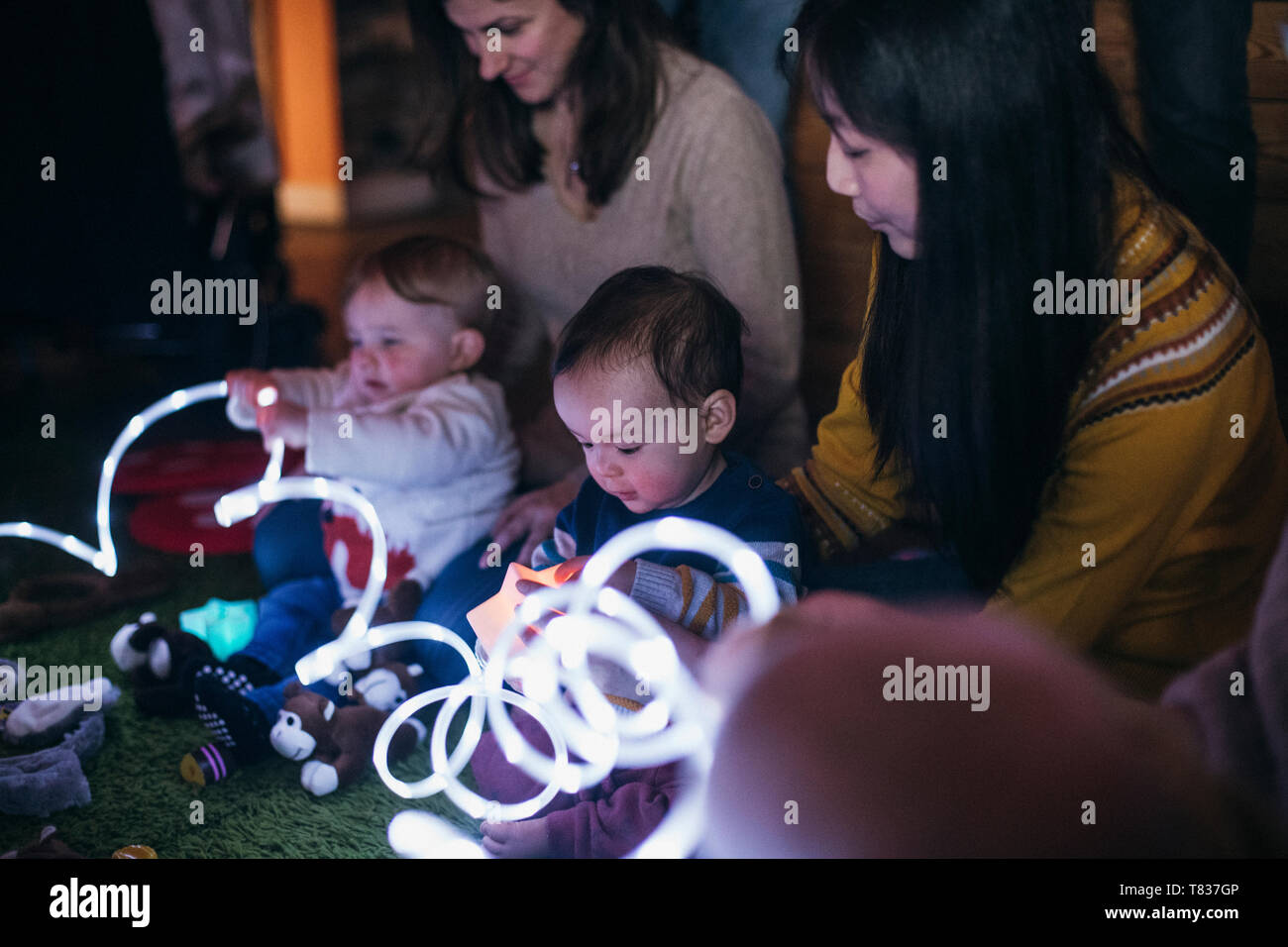 Mutter und Baby sensorische spielen Gruppe sind mit LED-Beleuchtung und Spielzeug für die Entwicklung spielen. Stockfoto