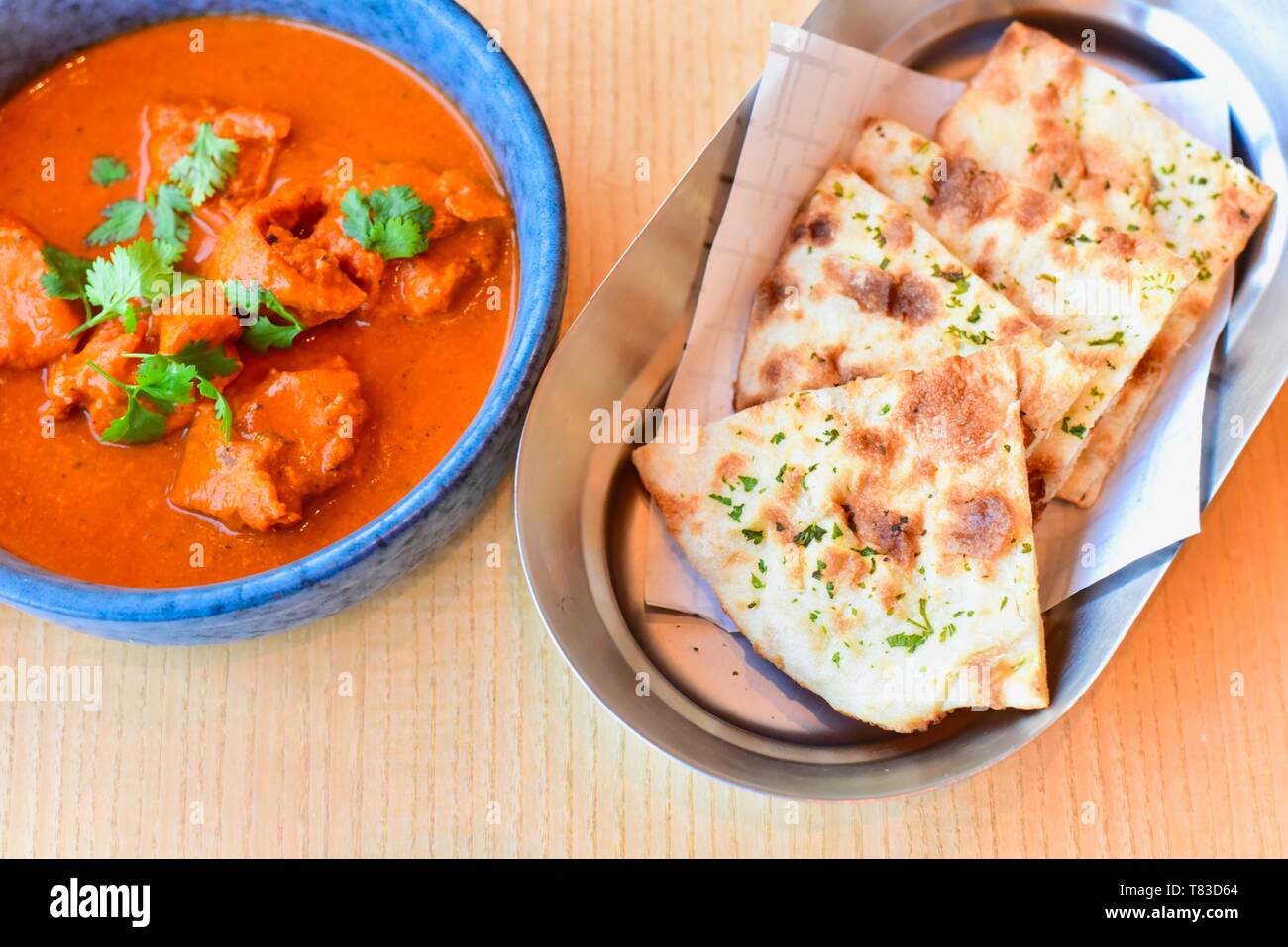 Indian Butter Chicken mit frisch gebackenen Naan Brot Stockfoto