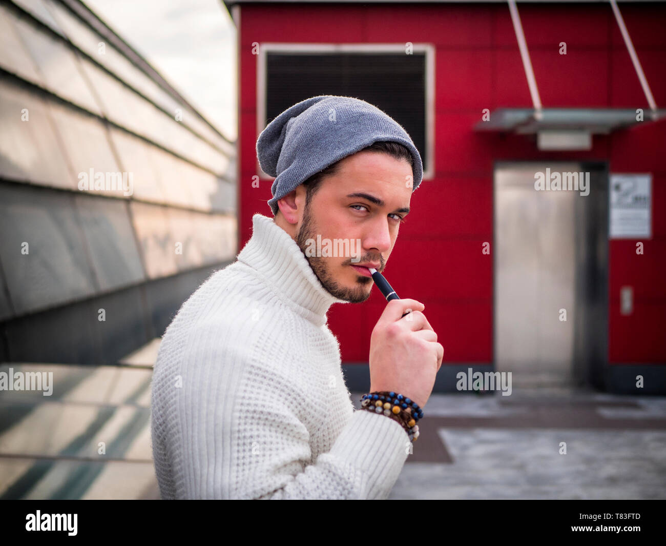 Junger Mann vaping, Rauchen E-Zigarette im Freien Stockfoto