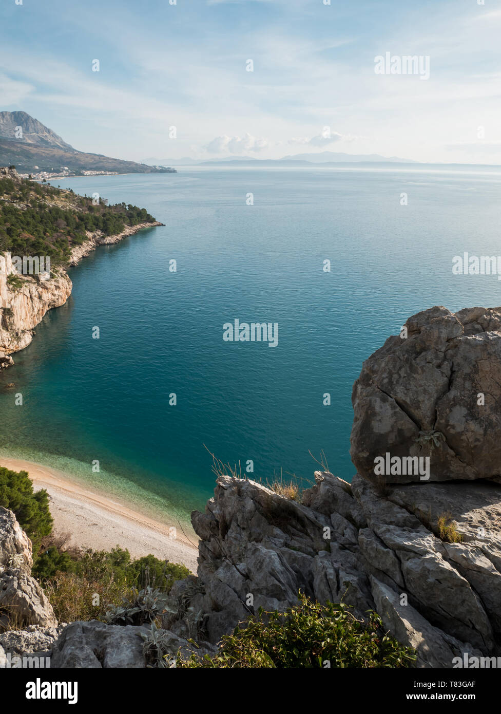 Felsige Küste mit Blick auf den kleinen versteckten Strand und blaues Meer in Kroatien am sonnigen Sommertag Stockfoto