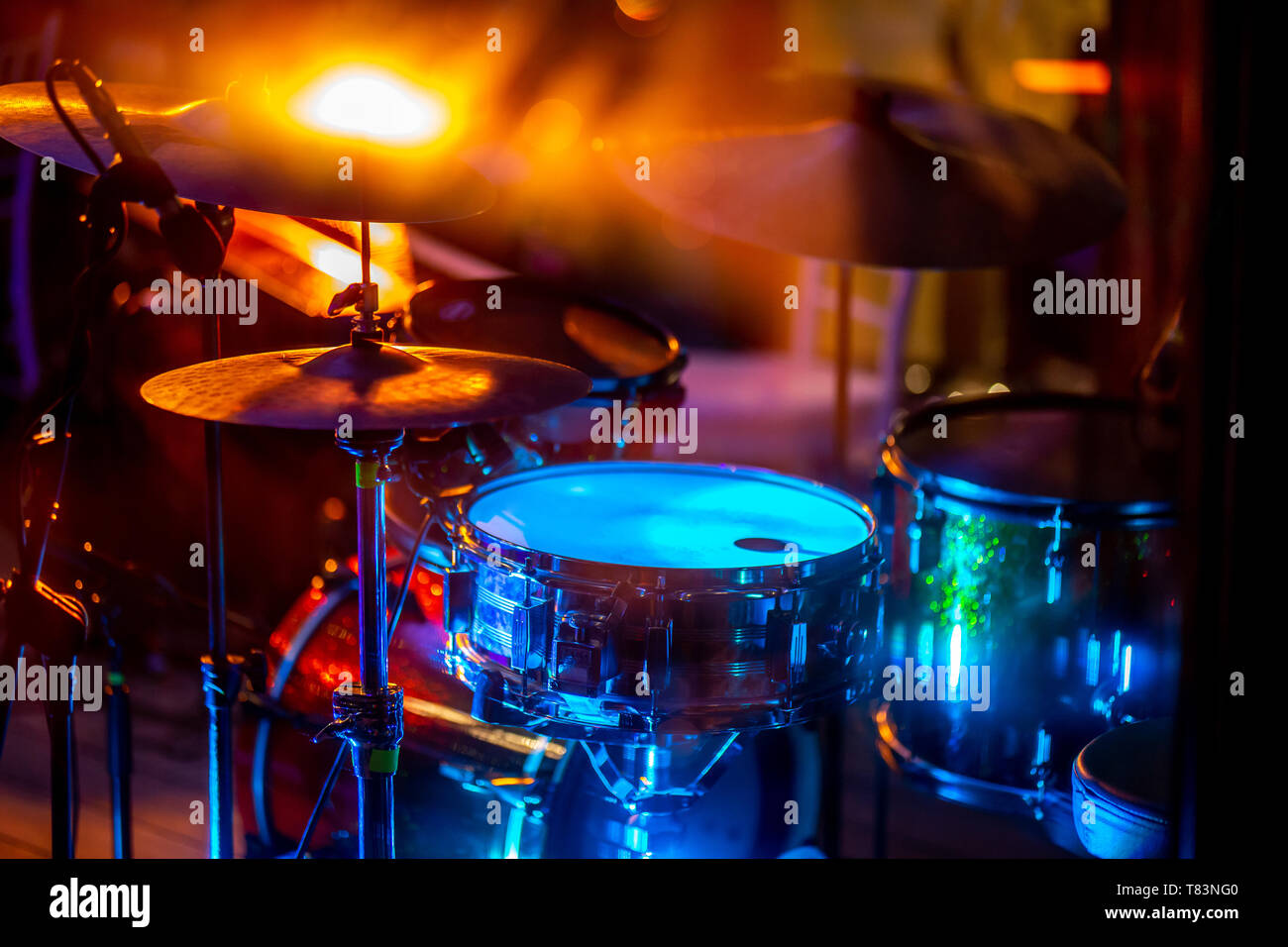 Leer abstrakte Licht beleuchteten Bühne mit Schlagzeug und Mikrofon. Trommeln in buntes Licht während der Feierlichkeiten auf der Bühne. Stockfoto