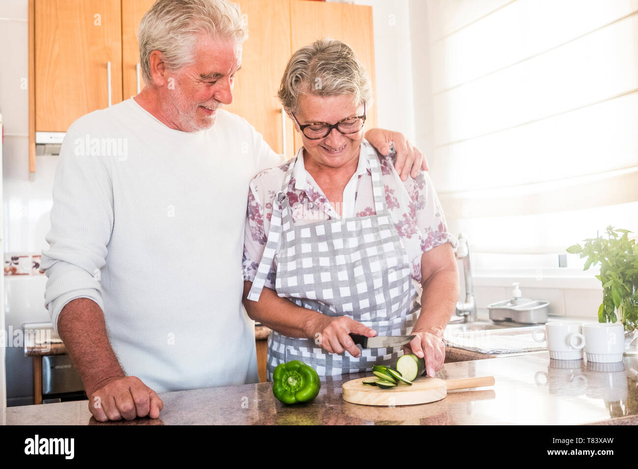 Gerne echten verliebtes Paar Erwachsene ältere Menschen im Ruhestand Mann und Frau genießen der Startseite Aktivitäten in der Küche Schneiden von Gemüse gesund zu essen, w Stockfoto