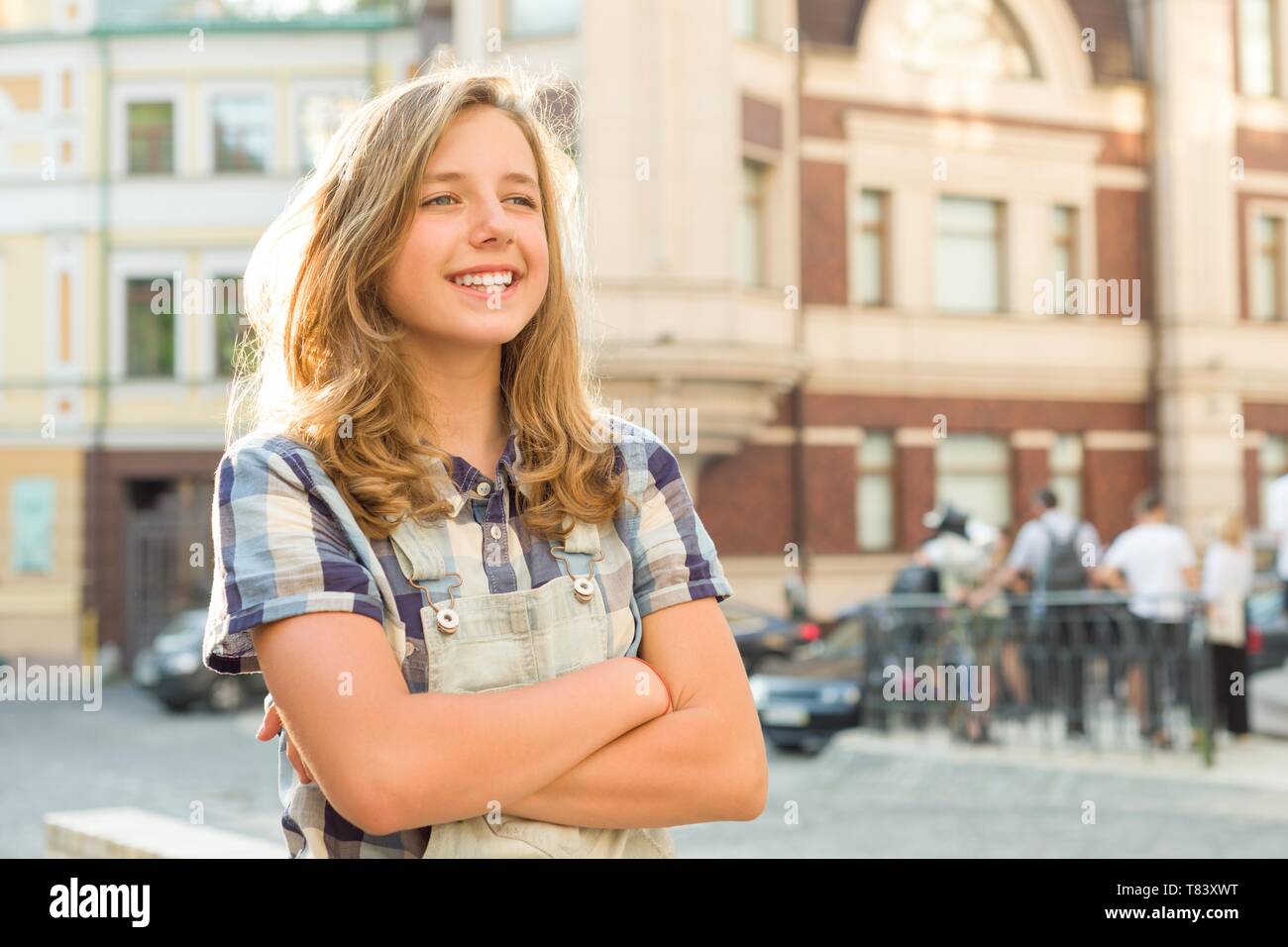 Outdoor Portrait von lächelnden Teenager Girl 12, 13 Jahre alt auf Stadt Straße, Mädchen mit gefalteten Händen, kopieren. Stockfoto