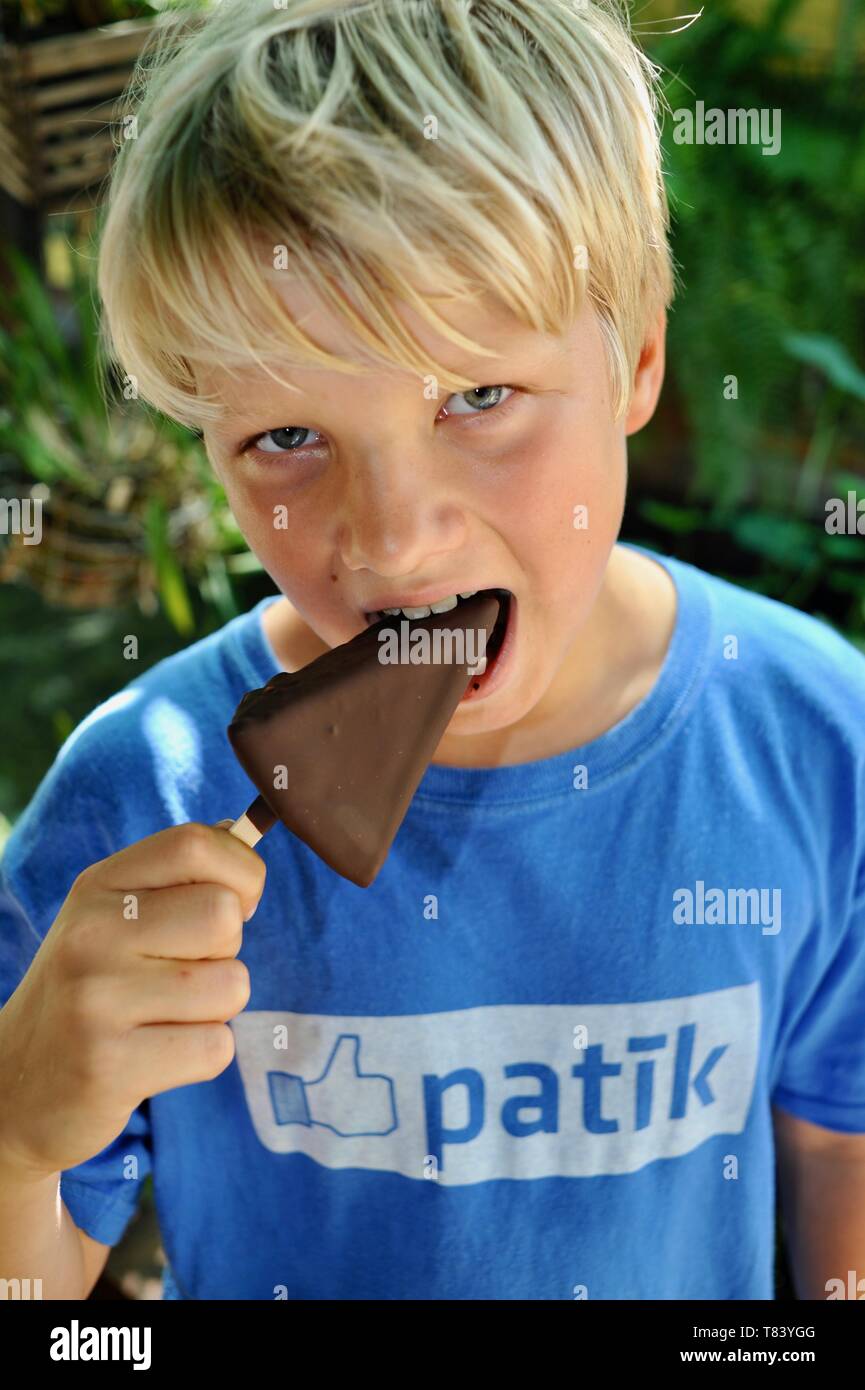 Nette Junge, Junge mit blondem Haar, blaue Augen, Alter 10-12 und das Tragen von estnischen Facebook t-shirt, Essen eine gefrorene Dessert behandeln, Key West, Florida, USA Stockfoto