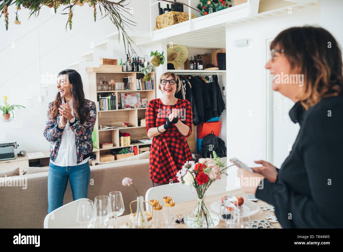 Freunde händeklatschen an der Feier im Loft Büro Stockfoto