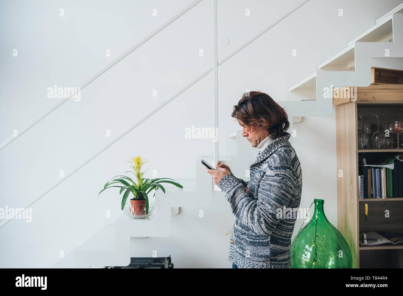 Mann mit Smartphone im Loft Büro Stockfoto