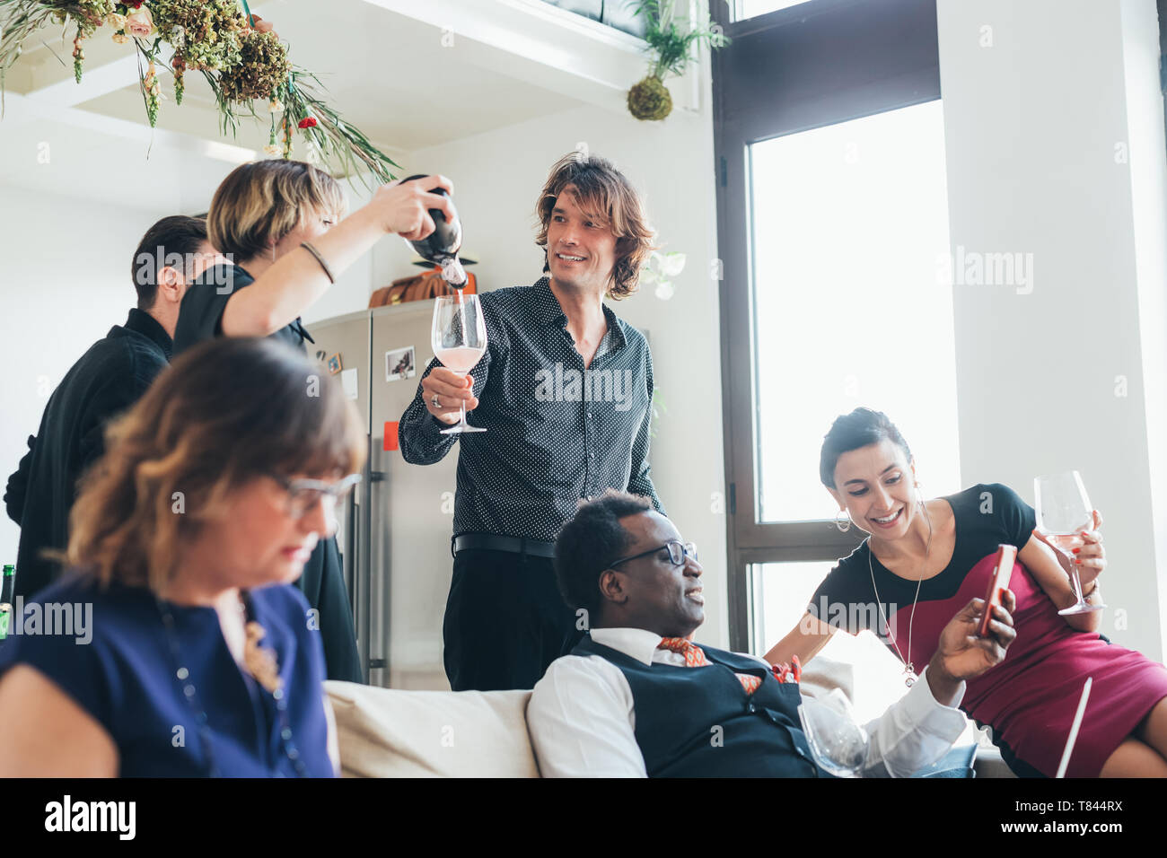 Unternehmer und Unternehmerinnen feiern mit Wein in loft Büro Stockfoto