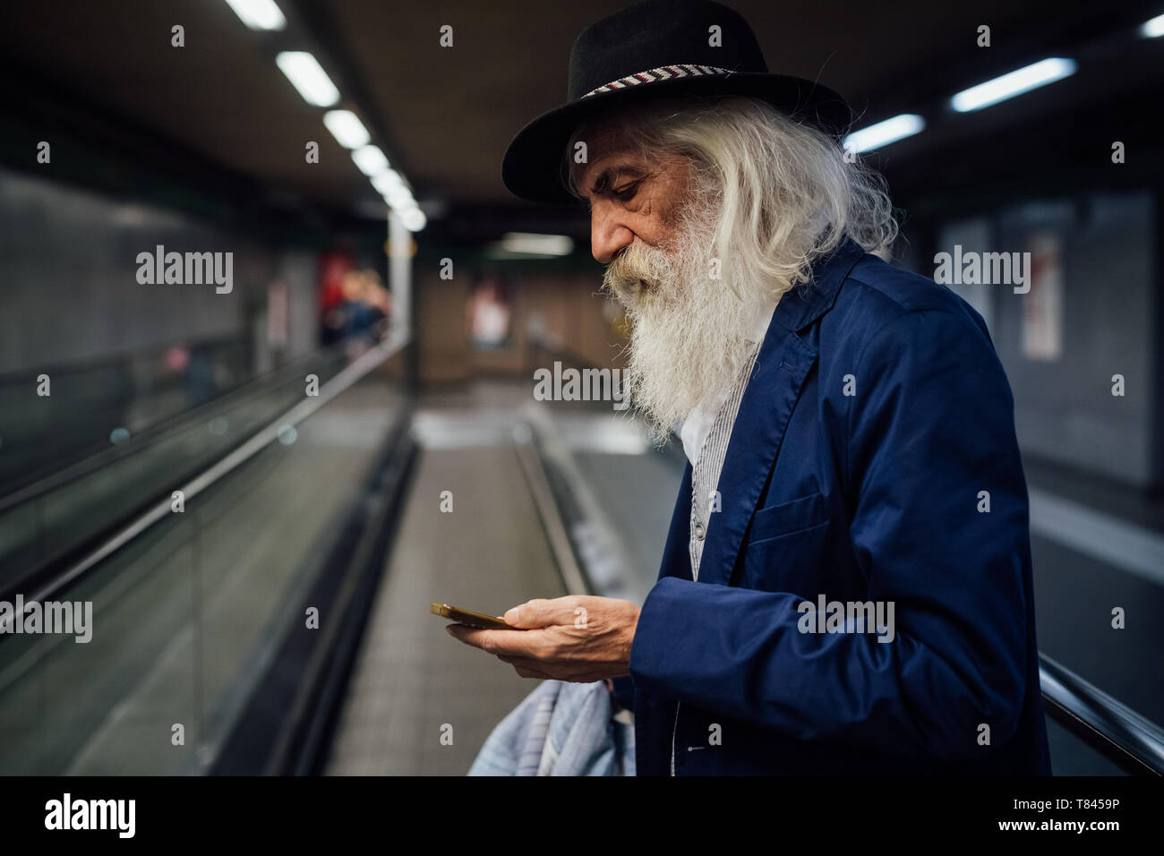 Senior Geschäftsmann mit Smartphone im Terminal Stockfoto